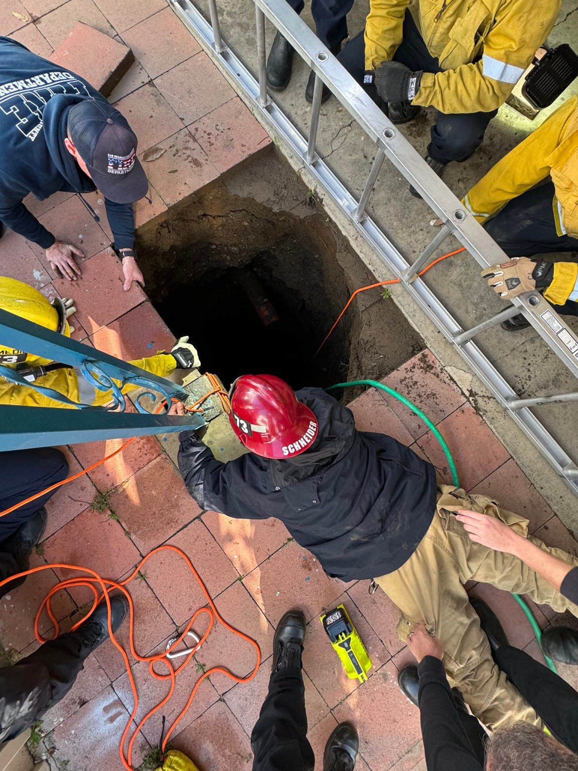 Rescue crews work to rescue a woman trapped in a sinkhole in Fontana on Feb. 8, 2024.