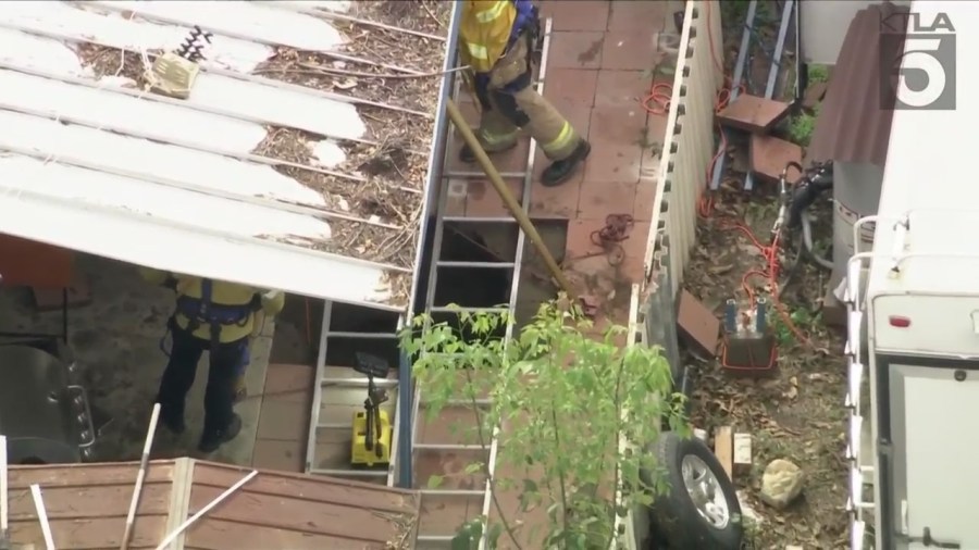 Crews work to rescue a woman from a sinkhole in Fontana on Feb. 8, 2024.