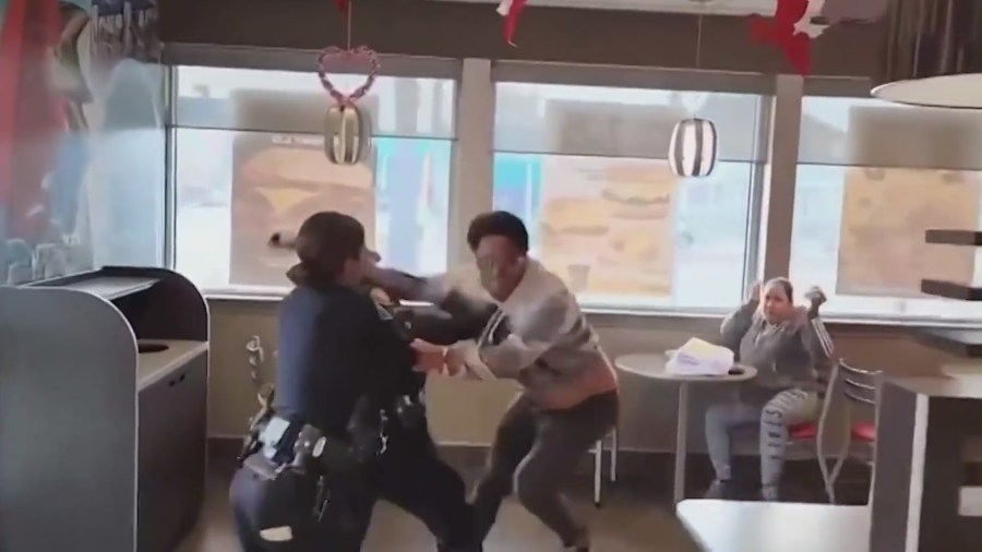 The moment officers chase a suspected child predator through a Carl's Jr. restaurant in Long Beach with the help of “Black Biden,” seen in the red hoodie. (@black_biden8383)