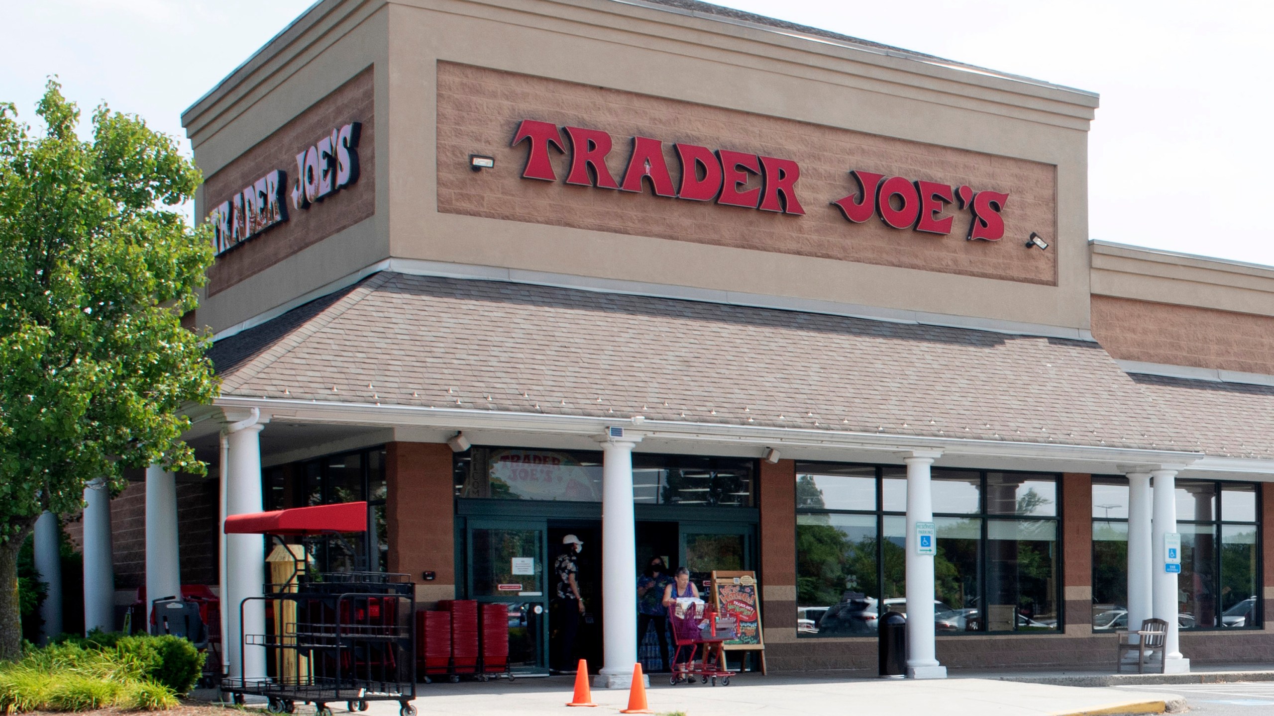 FILE - A shopper pushes a cart from the Trader Joe's supermarket on July 28, 2022, in Hadley, Mass. Trader Joe's mini canvas tote is the latest item to cause a stir on social media, so much so that resellers are taking advantage of the hype. (Carol Lollis/The Daily Hampshire Gazette via AP, File)