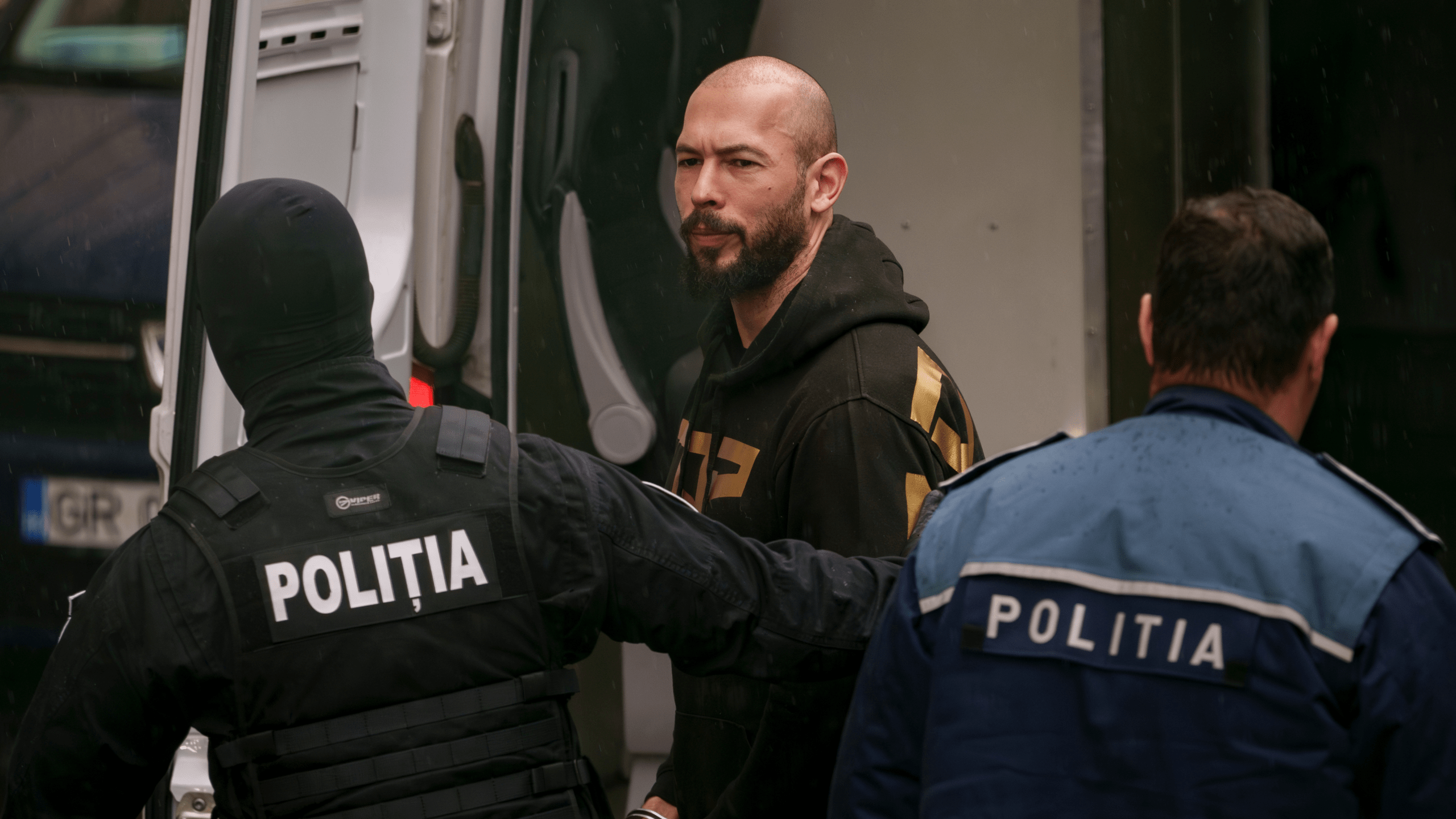 Police officers escort Andrew Tate, center, handcuffed, to the Court of Appeal in Bucharest, Romania, Tuesday, March 12, 2024.