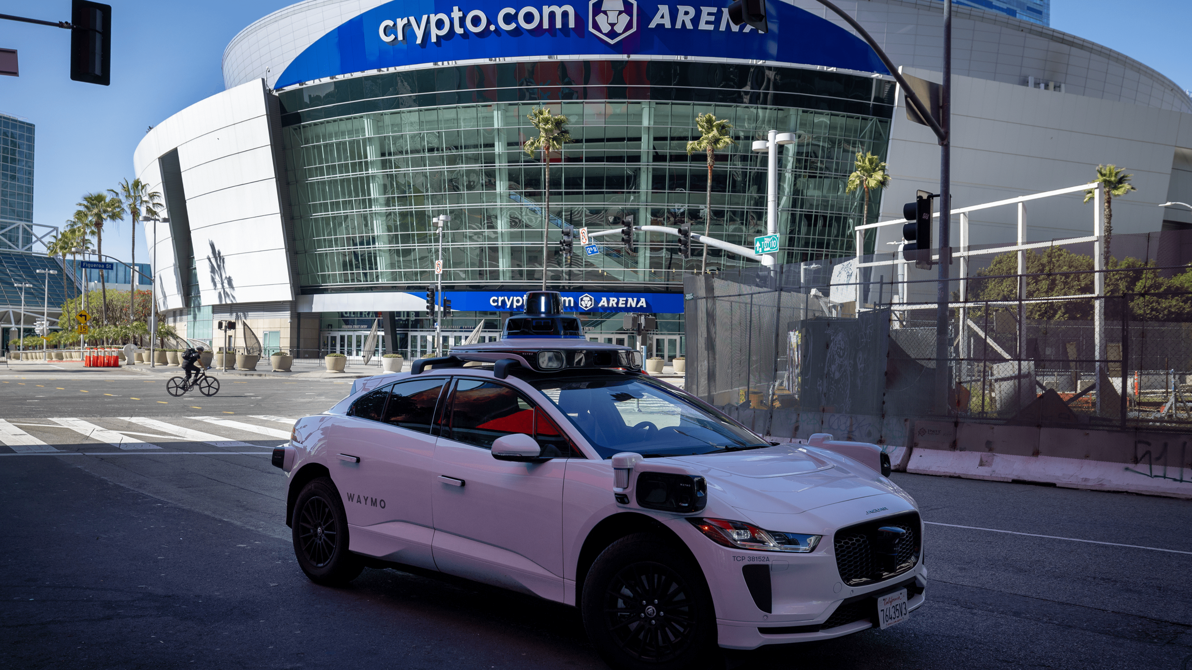 A Waymo robotaxi Jaguar I-PACEs driverless car makes a stop near Crypto.com Arena while driving around downtown in Los Angeles Monday, March 11, 2024.