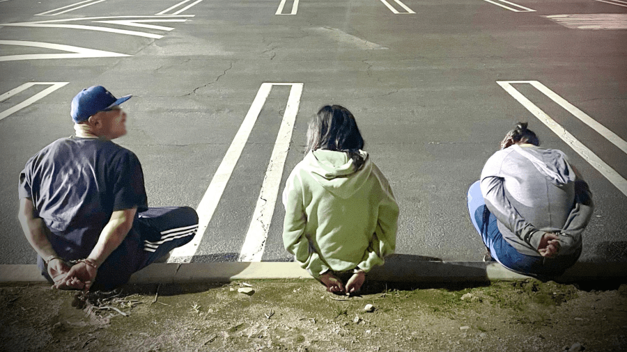 Retail theft suspects are seen in handcuffs in Upland on March 19, 2024.