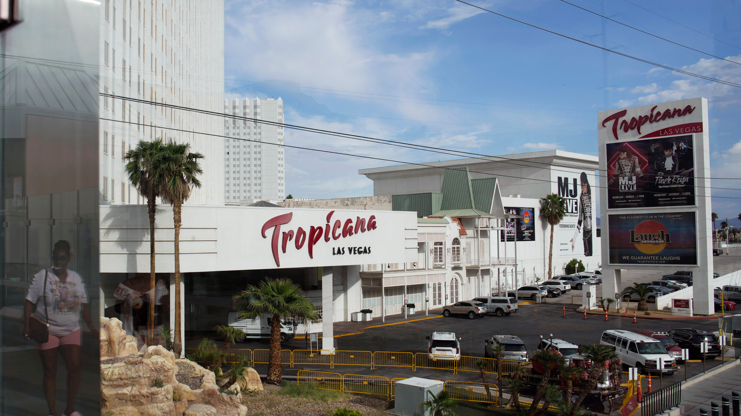 A person, reflected in glass, walks near the Tropicana Las Vegas on May 16, 2023, in Las Vegas.