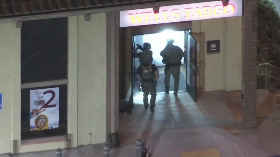 Officers enter to inspect a Wells Fargo bank after a bomb threat on March 26, 2024. (KTLA)