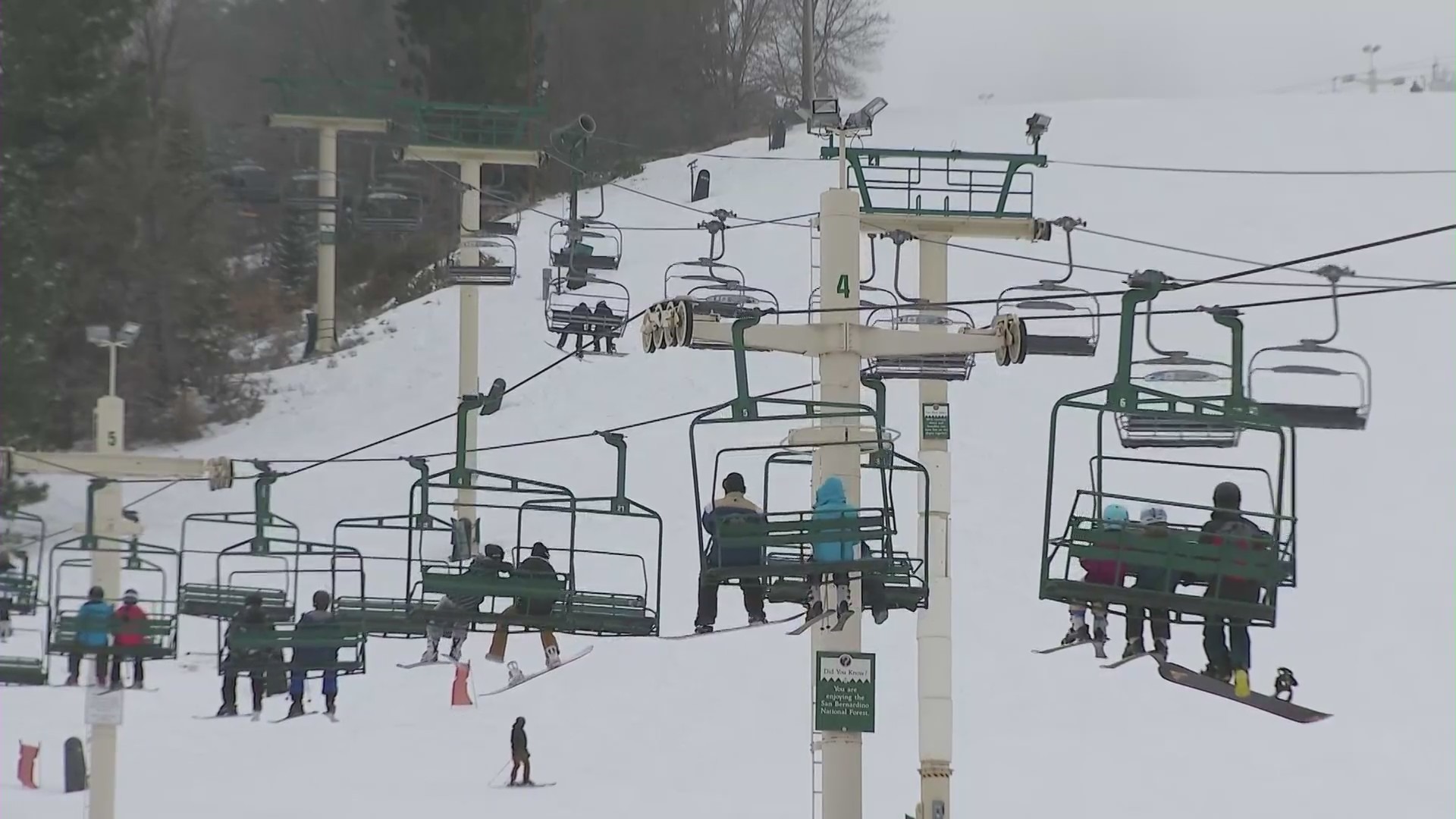 Skiers and snowboarders riding chair lifts at Mountain High Resort in Wrightwood, California. (KTLA)