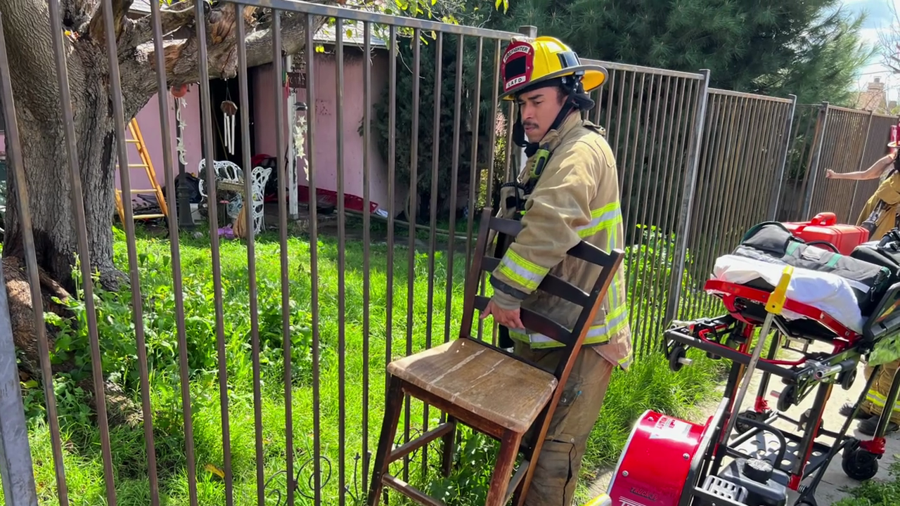 A Los Angeles firefighter removes furniture from a home that went up in flames in Sun Valley on March 7, 2024.