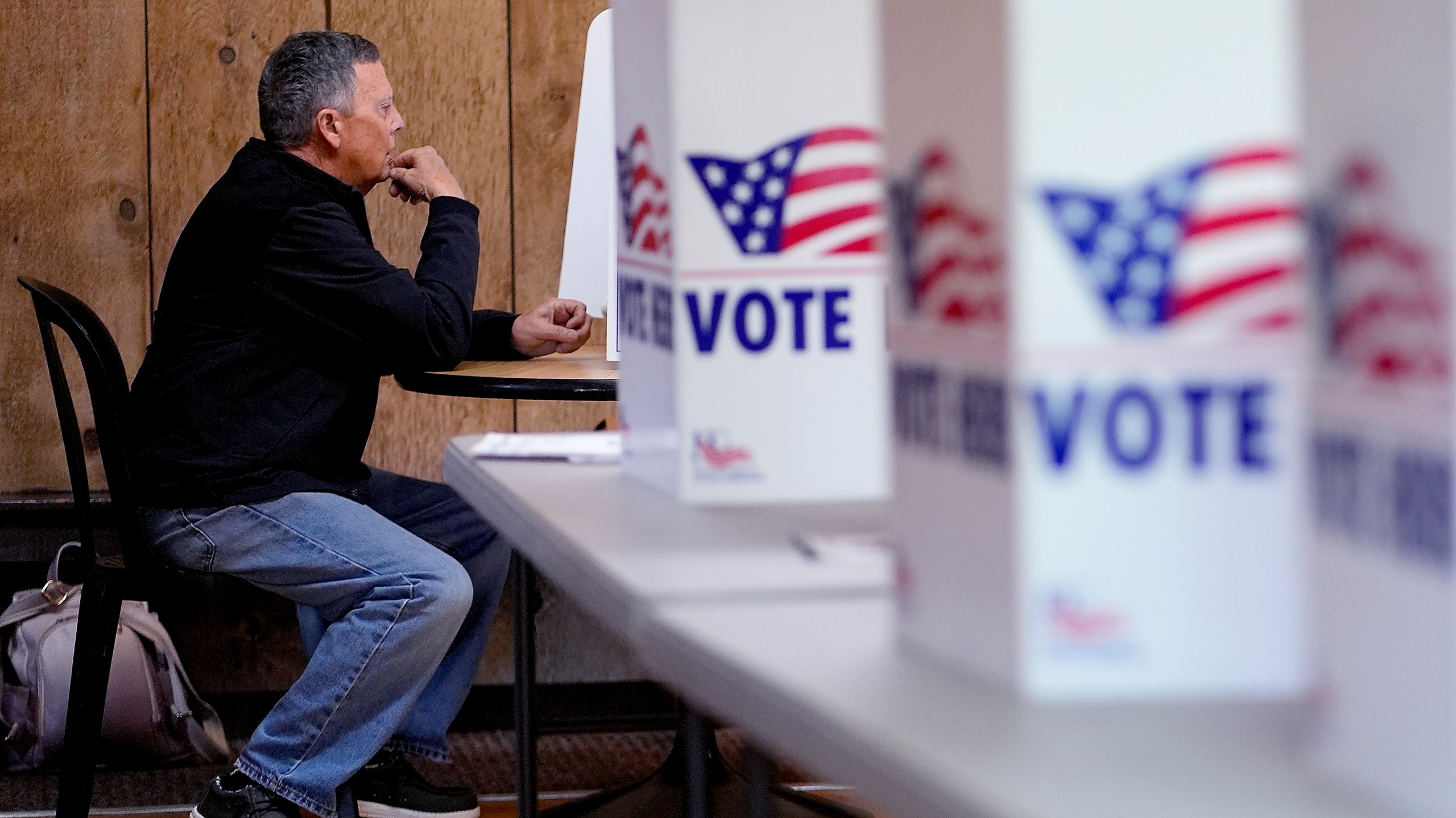 A man votes Tuesday, April 2, 2024, at Yellow Rock Barn in Kansas City, Mo. Voters are being asked to decide whether to extend a sales tax to fund a new baseball stadium for the Kansas City Royals and football stadium improvements for the Kansas City Chiefs. (AP Photo/Charlie Riedel)