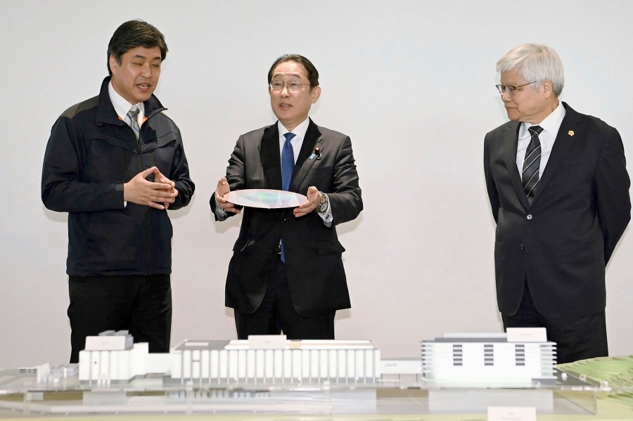 Japanese Prime Minister Fumio Kishida, center, is briefed as he visits a plant of the Taiwan Semiconductor Manufacturing Co. in Kikuyo town, Kumamoto prefecture, southern Japan Saturday, April 6, 2024. At right is Taiwan Semiconductor Manufacturing Company CEO C.C. Wei. (Japan Pool/Kyodo News via AP)