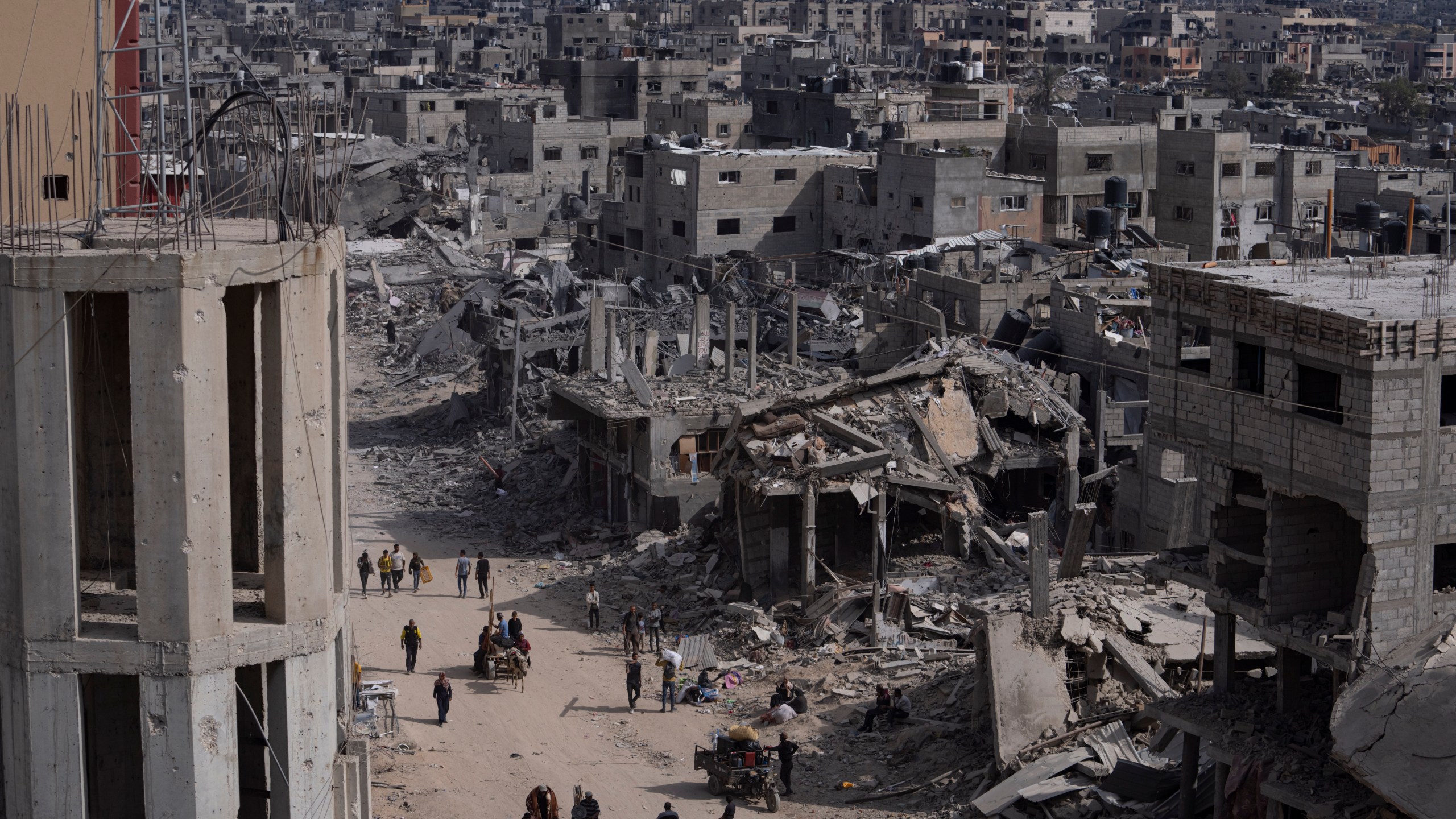 Palestinians walk through the destruction in the wake of an Israeli air and ground offensive in Khan Younis, southern Gaza Strip, Monday, April 8, 2024. Israel says it has withdrawn its last ground troops from the city, ending a four-month operation. (AP Photo/Fatima Shbair)