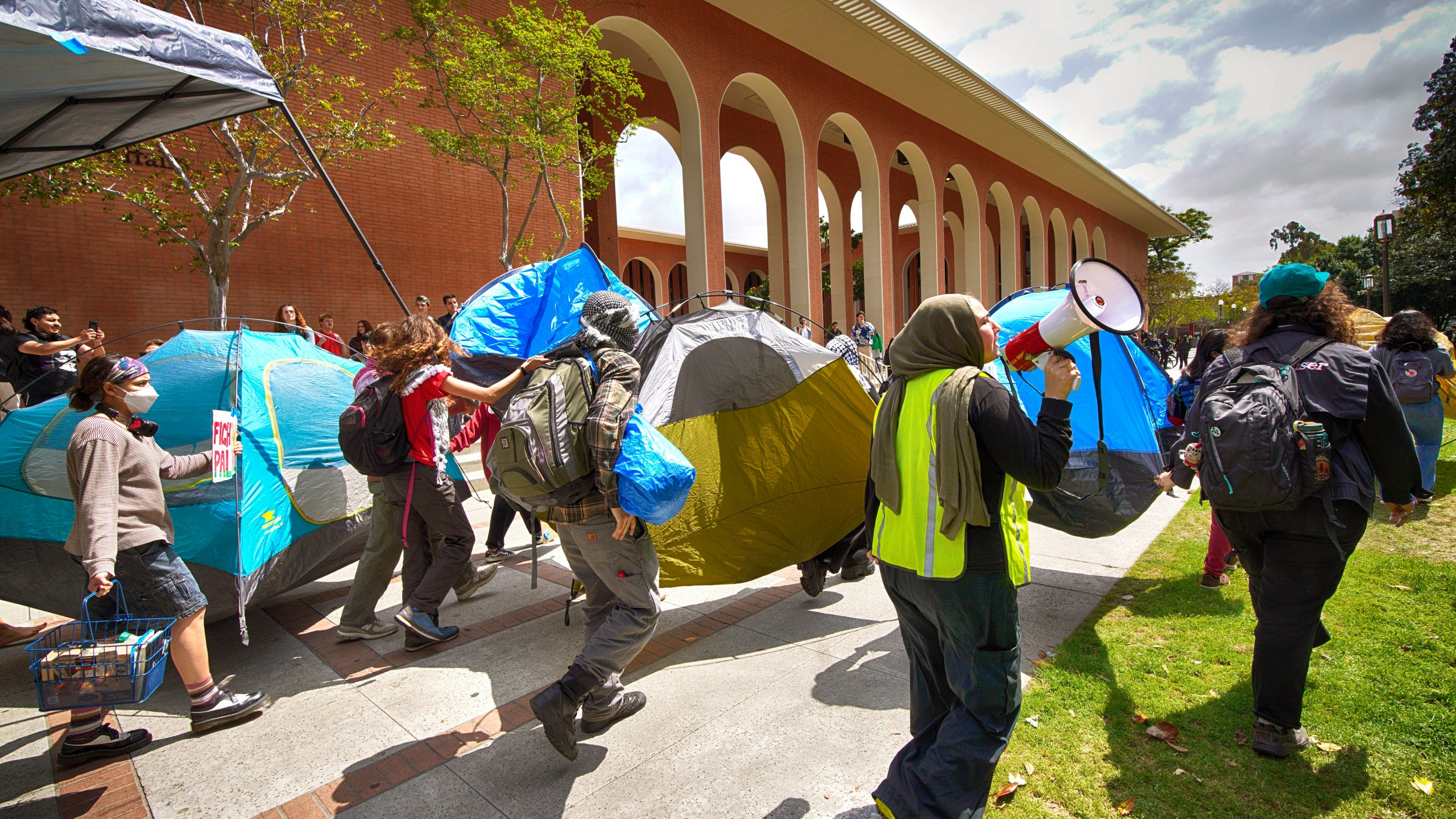 University of Southern California protesters carry a tents around Alumni Park on the University of Southern California to keep security from removing them during a pro-Palestinian occupation on Wednesday, April 24, 2024 in Los Angeles. (AP Photo/Richard Vogel)