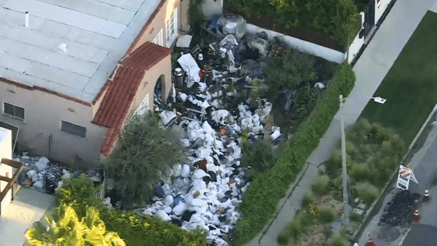 A Sky5 image shows piles of trash in the front yard of a Fairfax home on April 2, 2024.