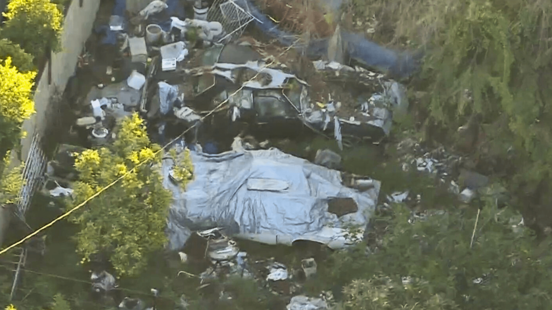 A Sky5 image shows piles of trash in the yard of a Fairfax home on April 2, 2024.