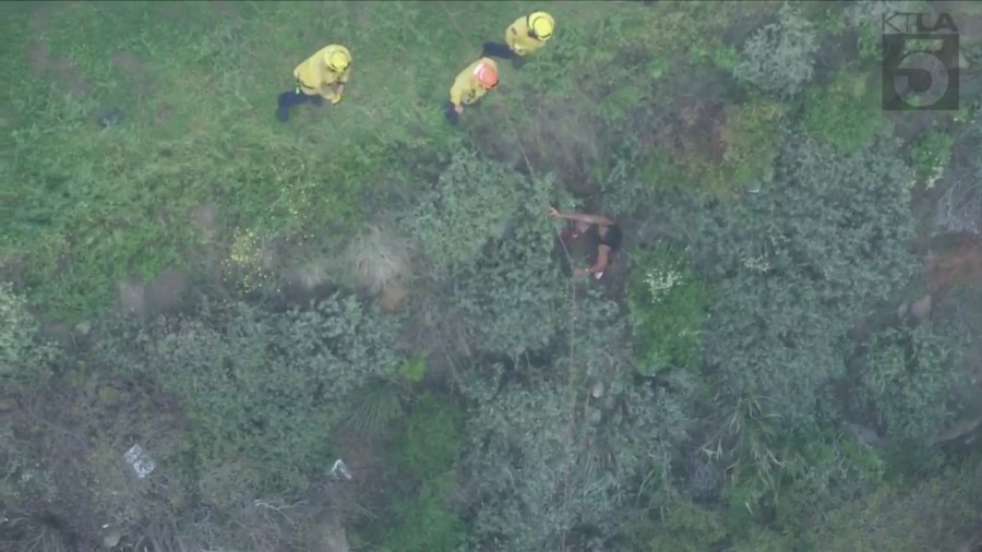 William Mbema, a witness who climbed down a cliff to help the injured driver, was being helped back up by emergency crews in Malibu on April 3, 2024. (KTLA)