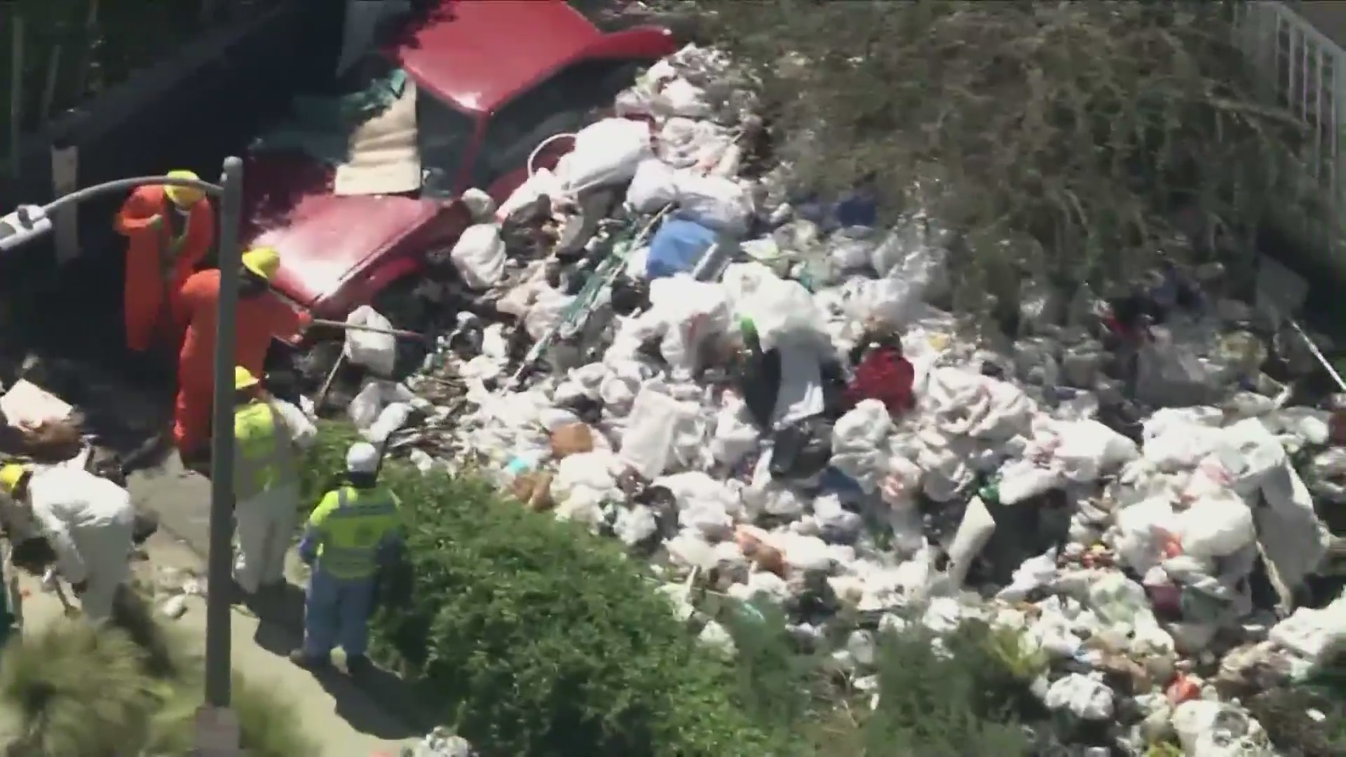 Crews began clearing mountains of trash and debris seen in the front yard of a Fairfax home in Los Angeles on April 3, 2024. (KTLA)