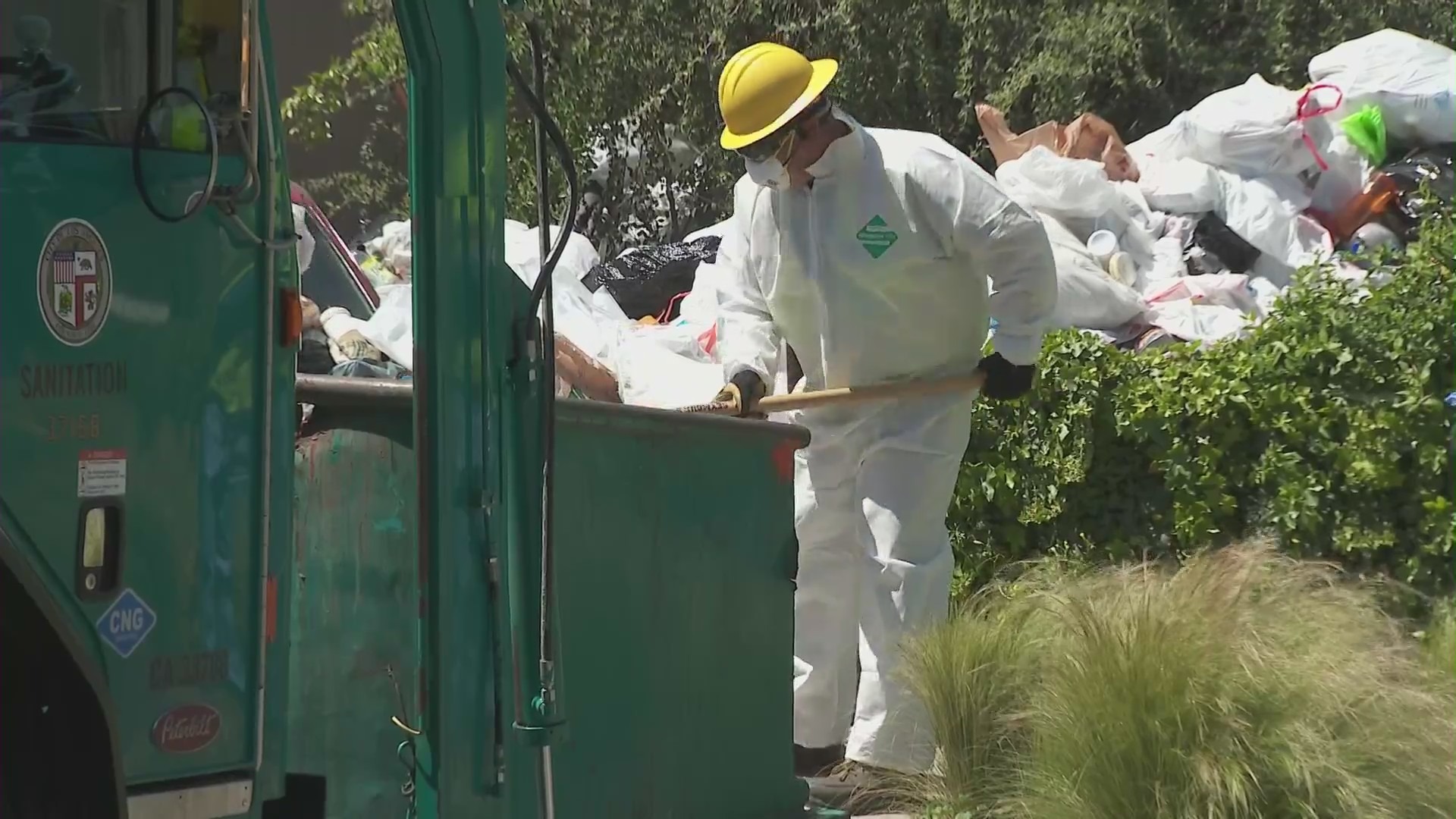 Crews began clearing mountains of trash and debris seen in the front yard of a Fairfax home in Los Angeles on April 3, 2024. (KTLA)