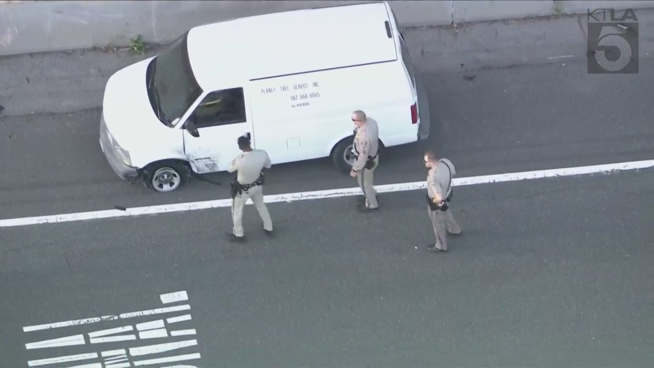 Officers surround the suspect again after he took off and pulled over at the Long Beach Boulevard exit. (KTLA)