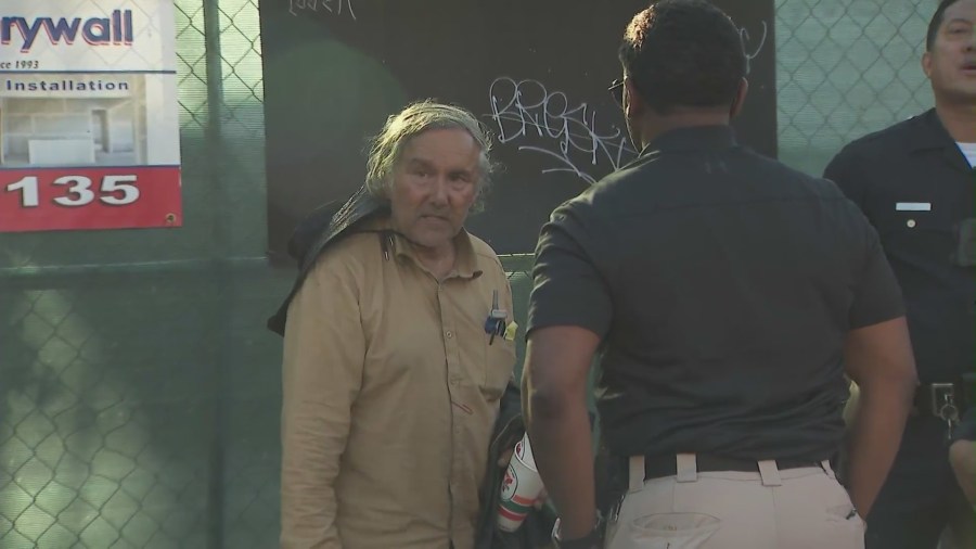 Crews speaking to the owner of the Fairfax "Trash House" in Los Angeles on April 3, 2024. (KTLA)