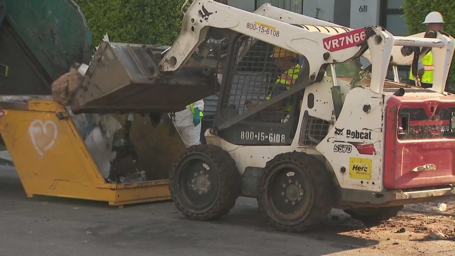 Crews began clearing mountains of trash and debris seen in the front yard of a Fairfax home in Los Angeles on April 3, 2024. (KTLA)