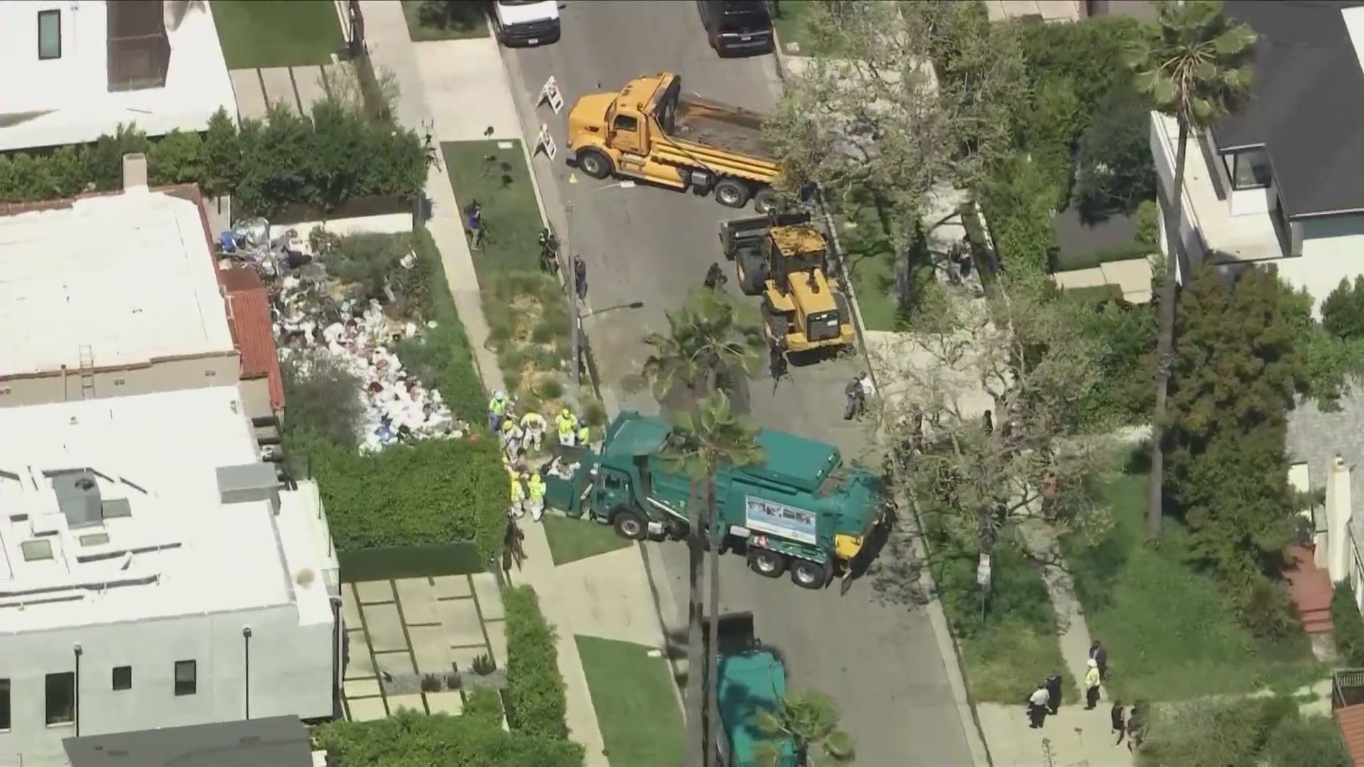 Crews began clearing mountains of trash and debris seen in the front yard of a Fairfax home in Los Angeles on April 3, 2024. (KTLA)