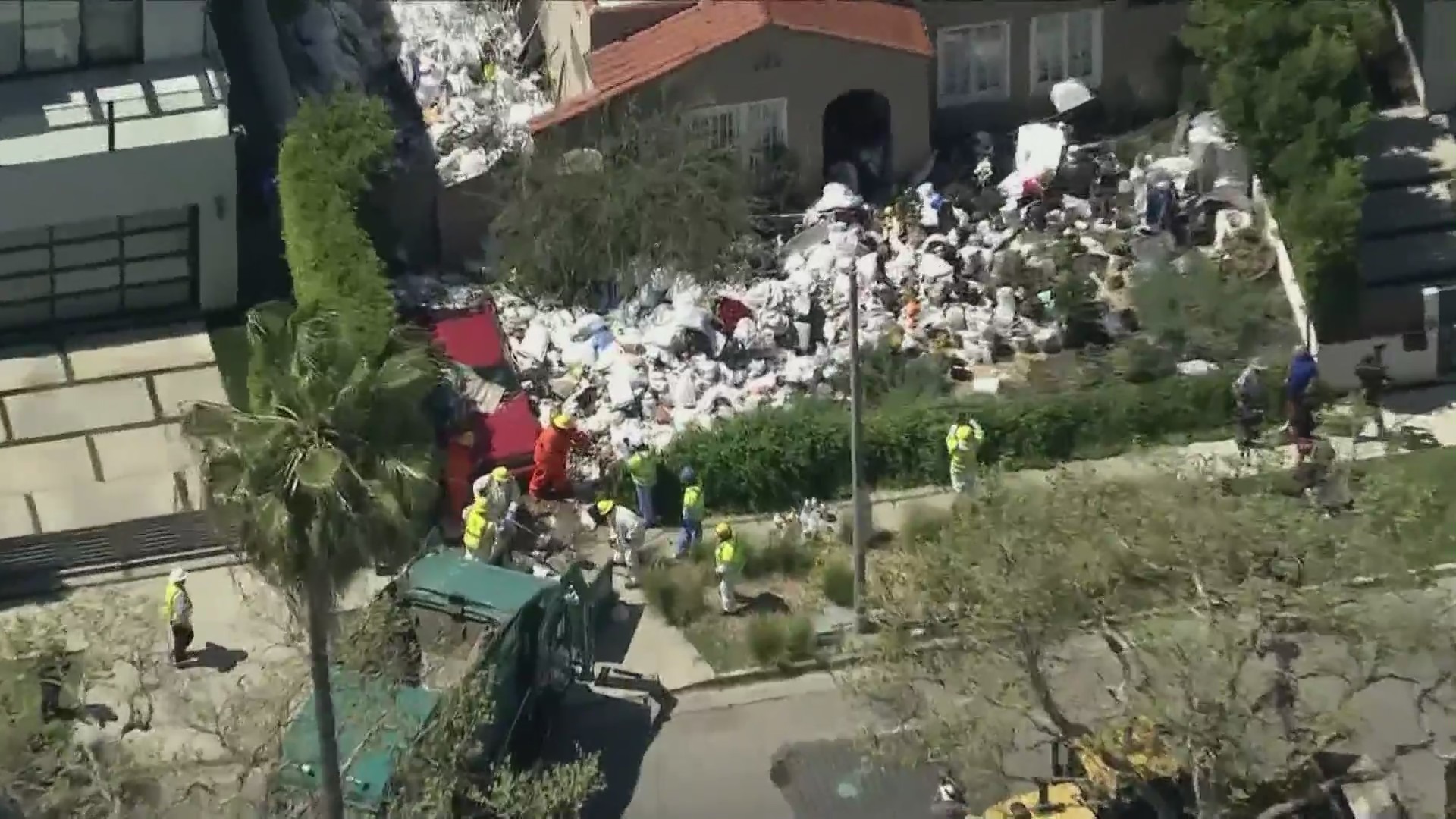 Crews began clearing mountains of trash and debris seen in the front yard of a Fairfax home in Los Angeles on April 3, 2024. (KTLA)