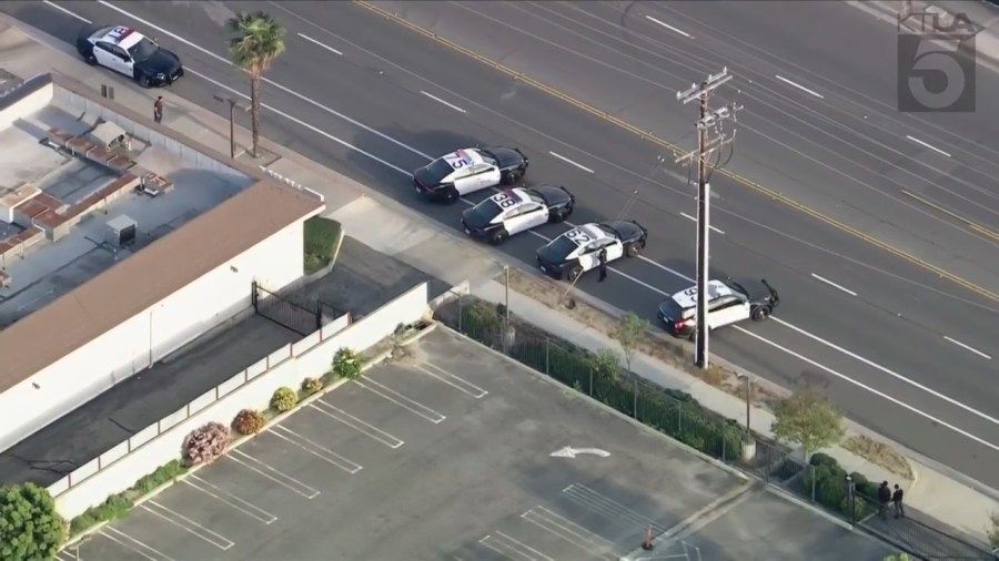 Police officers and SWAT Team members surround a housing complex after a 13-year-old boy was shot to death in Anaheim on April 17, 2024. (KTLA)