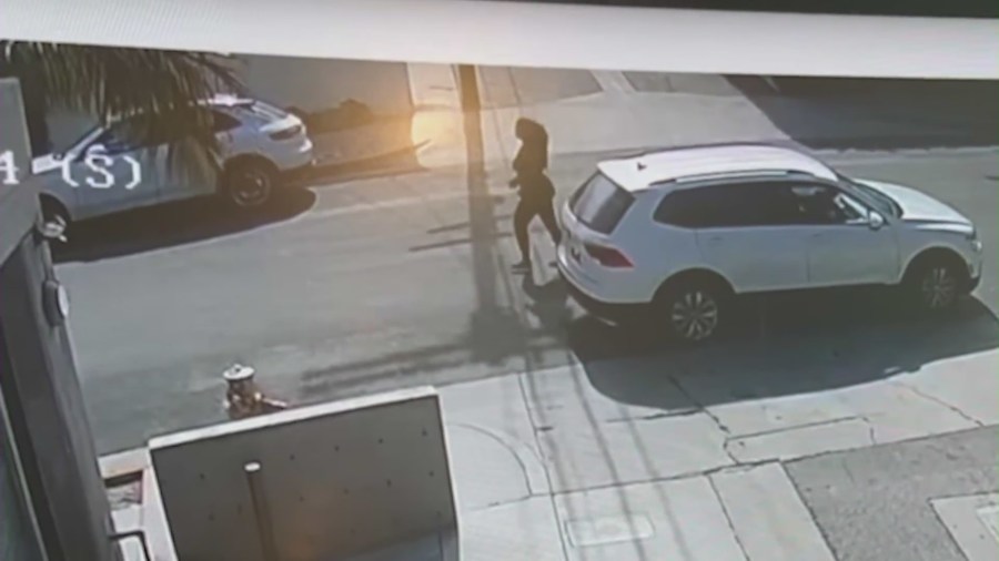 A woman exiting her Volkswagen Tiguan SUV to throw large bricks at vehicle windshields in Los Angeles.