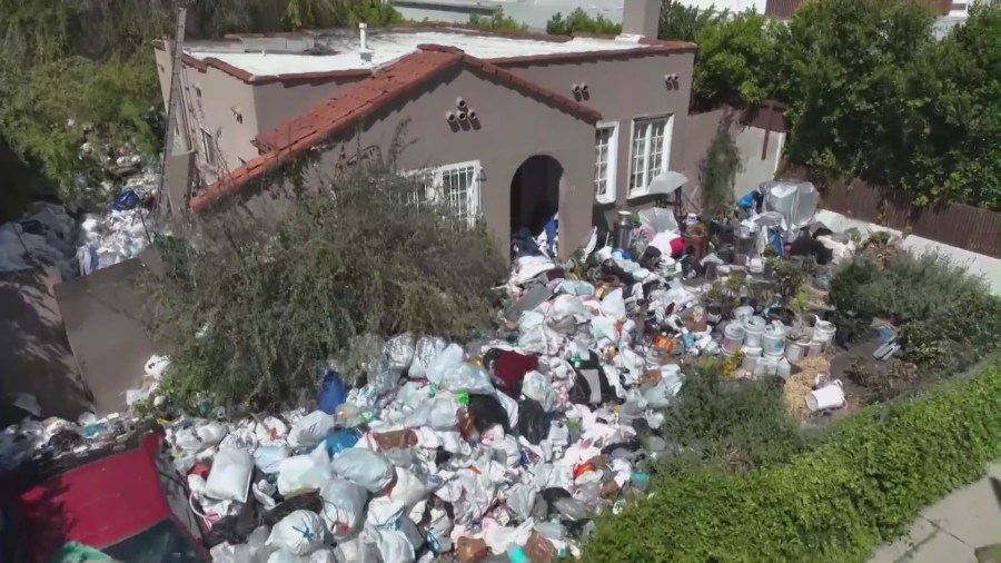 Piles of trash and debris seen in the front yard of a Fairfax home in Los Angeles in April 2024. (KTLA)