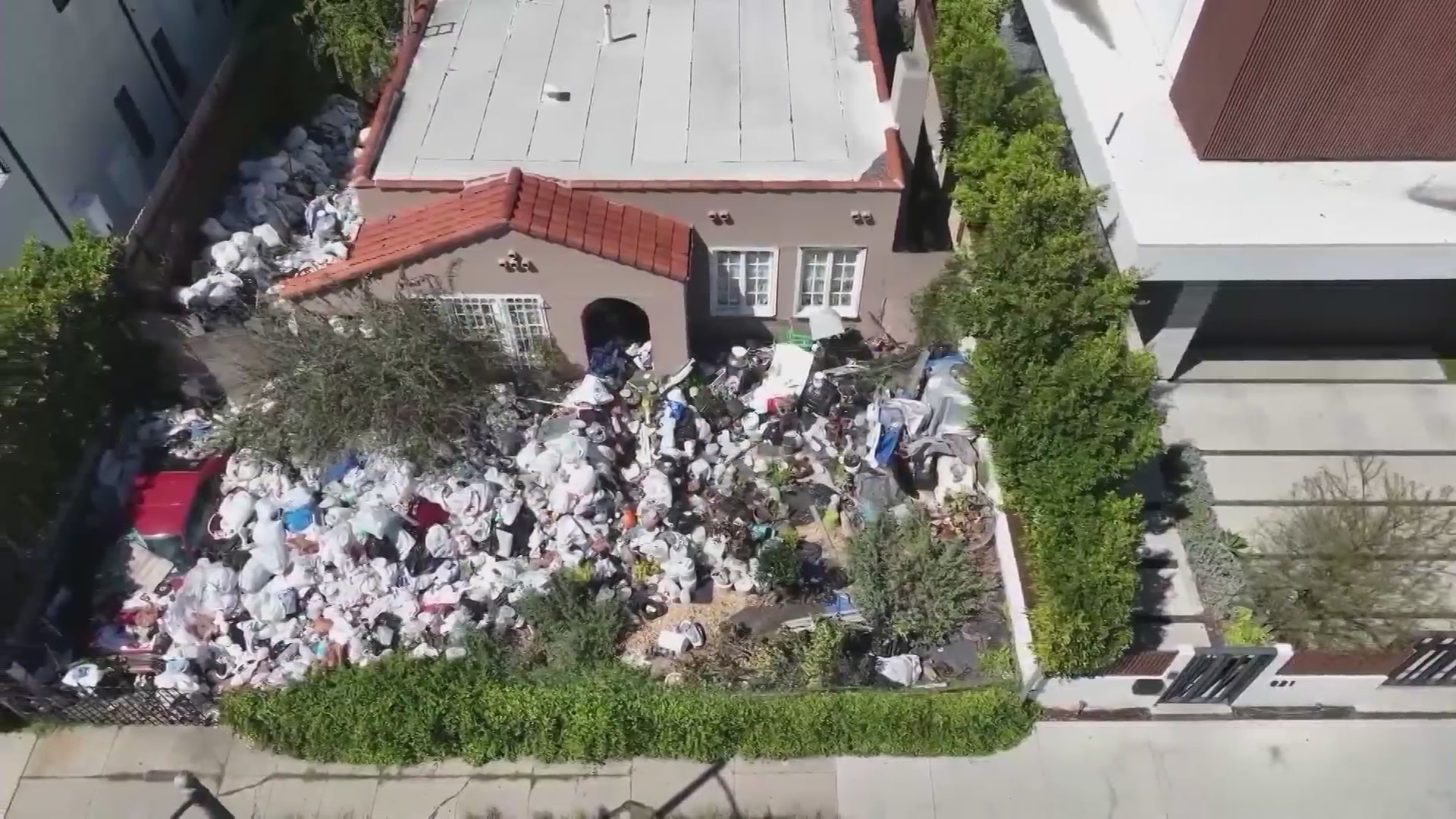 Piles of trash and debris seen in the front yard of a Fairfax home in Los Angeles on April 2, 2024. (KTLA)