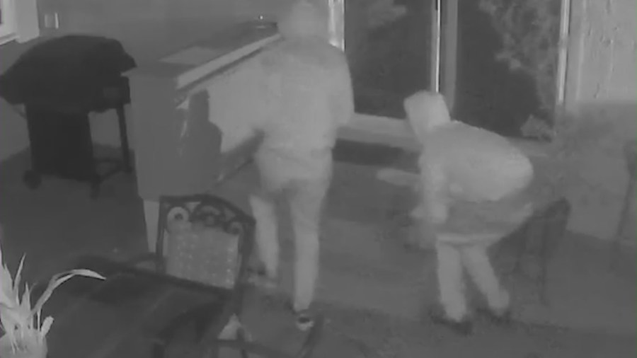 Two suspects smashing the window of a Westchester home in Los Angeles County amid a series of violent break-ins.