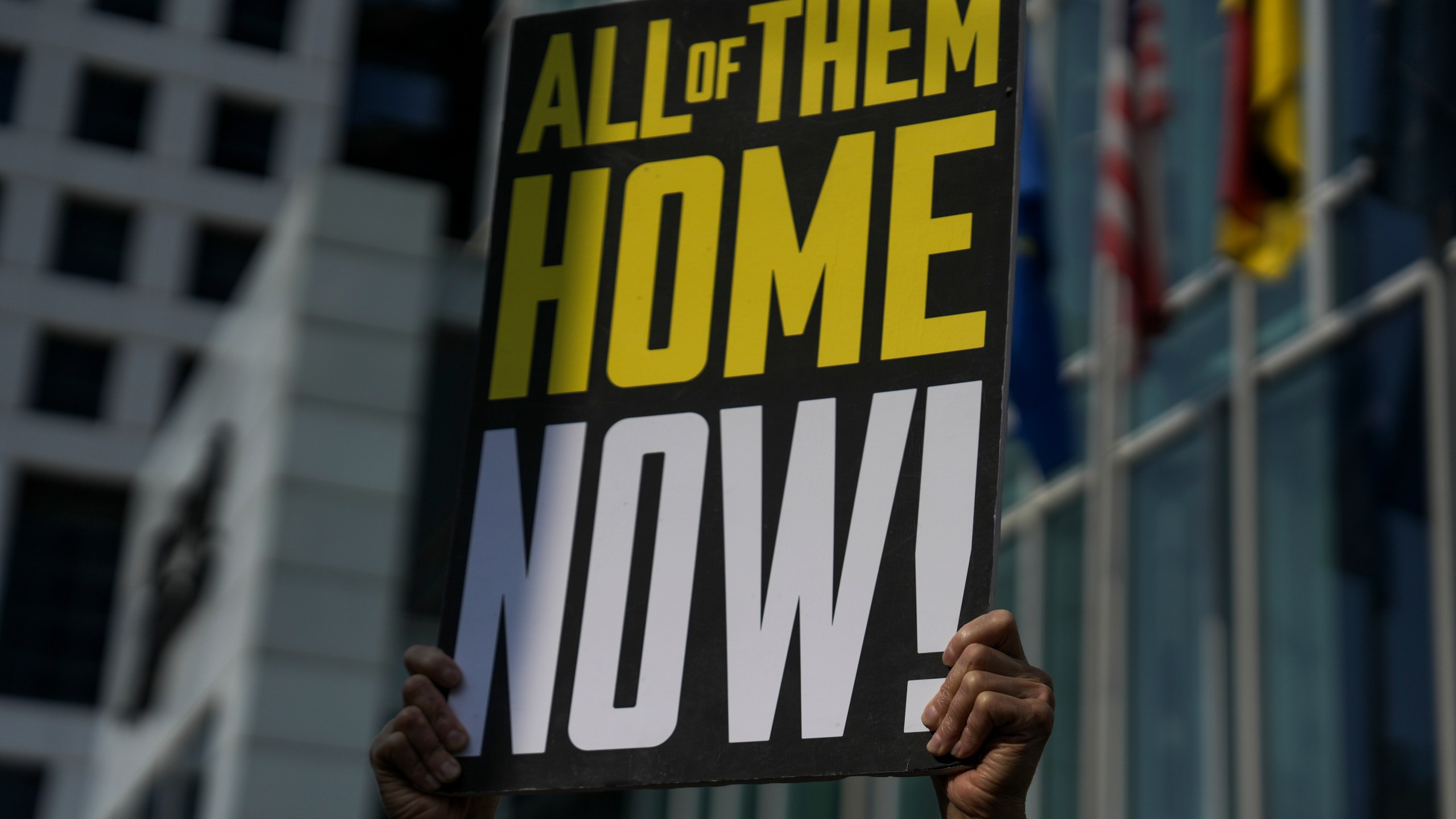 A woman holds a banner with families and supporters of Israeli hostages held by Hamas in Gaza during a protest calling for their return, outside a meeting between U.S. Secretary of State Antony Blinken and families of hostages in Tel Aviv, Israel, Wednesday, May 1, 2024. (AP Photo/Oded Balilty)