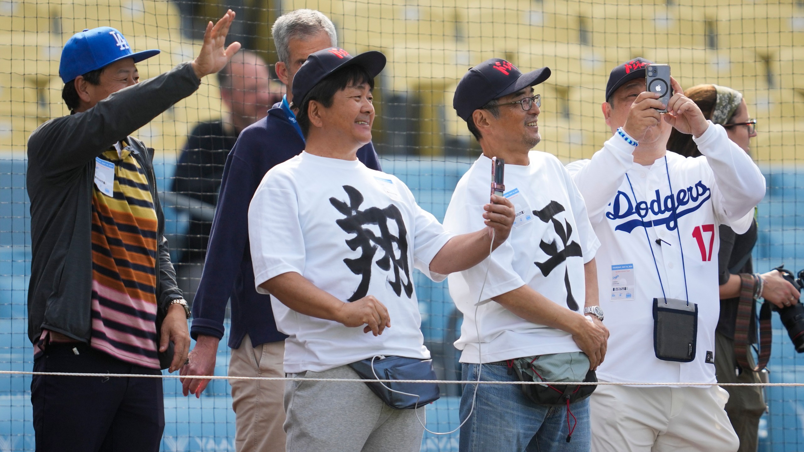 Los Angeles Dodgers fans wear Shohei Ohtani shirts as players workout before a baseball game against the Cincinnati Reds in Los Angeles, Thursday, May 16, 2024. (AP Photo/Ashley Landis)