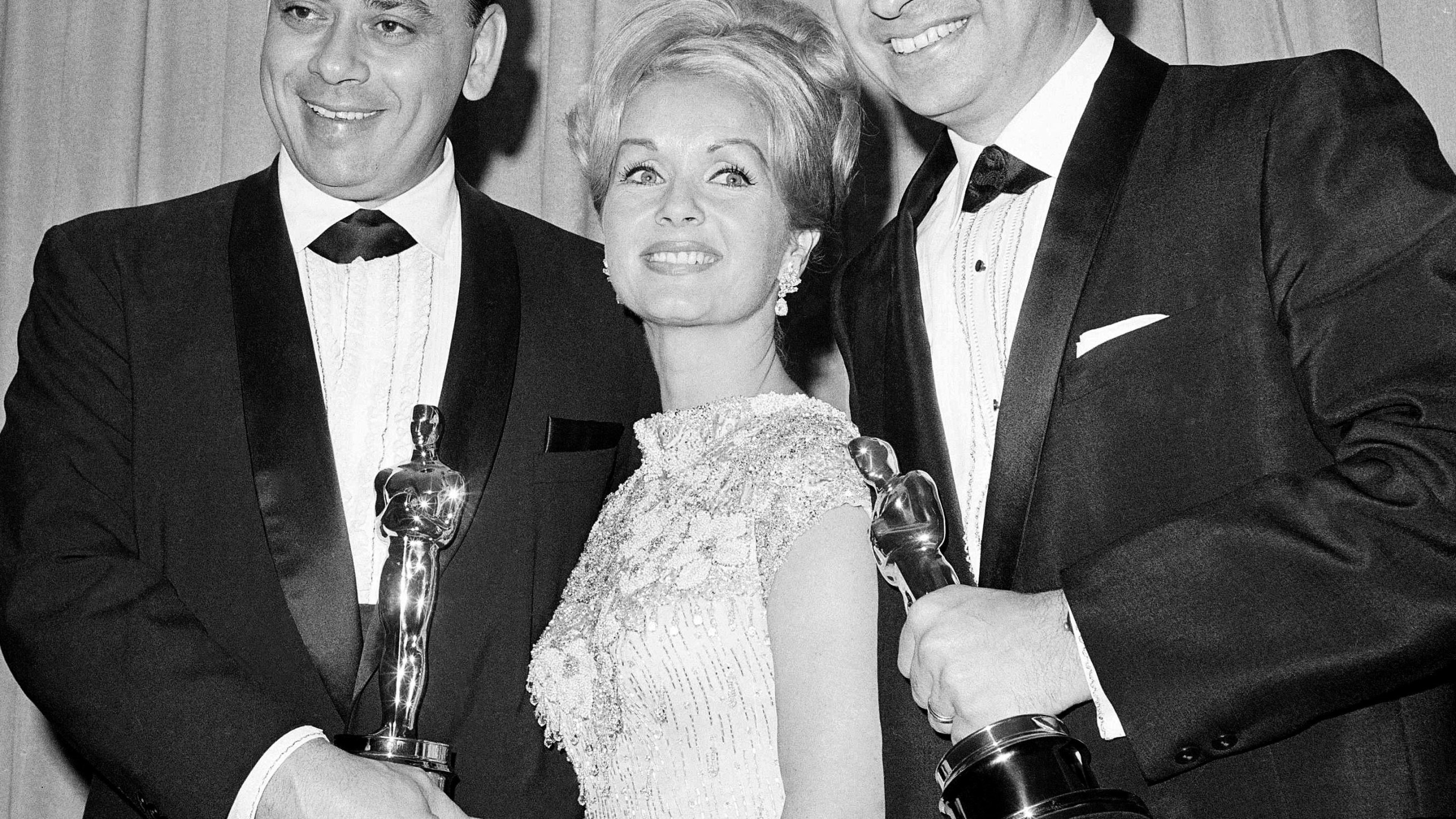 FILE - Actress Debbie Reynolds poses with Academy Awards winners for best music Richard M. Sherman, right, and Robert Sherman, left, who received the award for "Mary Poppins" in Santa Monica, Calif., April 5, 1965. Richard Sherman, one half of the prolific, award-winning pair of brothers who helped form millions of childhoods by penning classic Disney tunes, died Saturday, May 25, 2024. He was 95. (AP Photo/File)