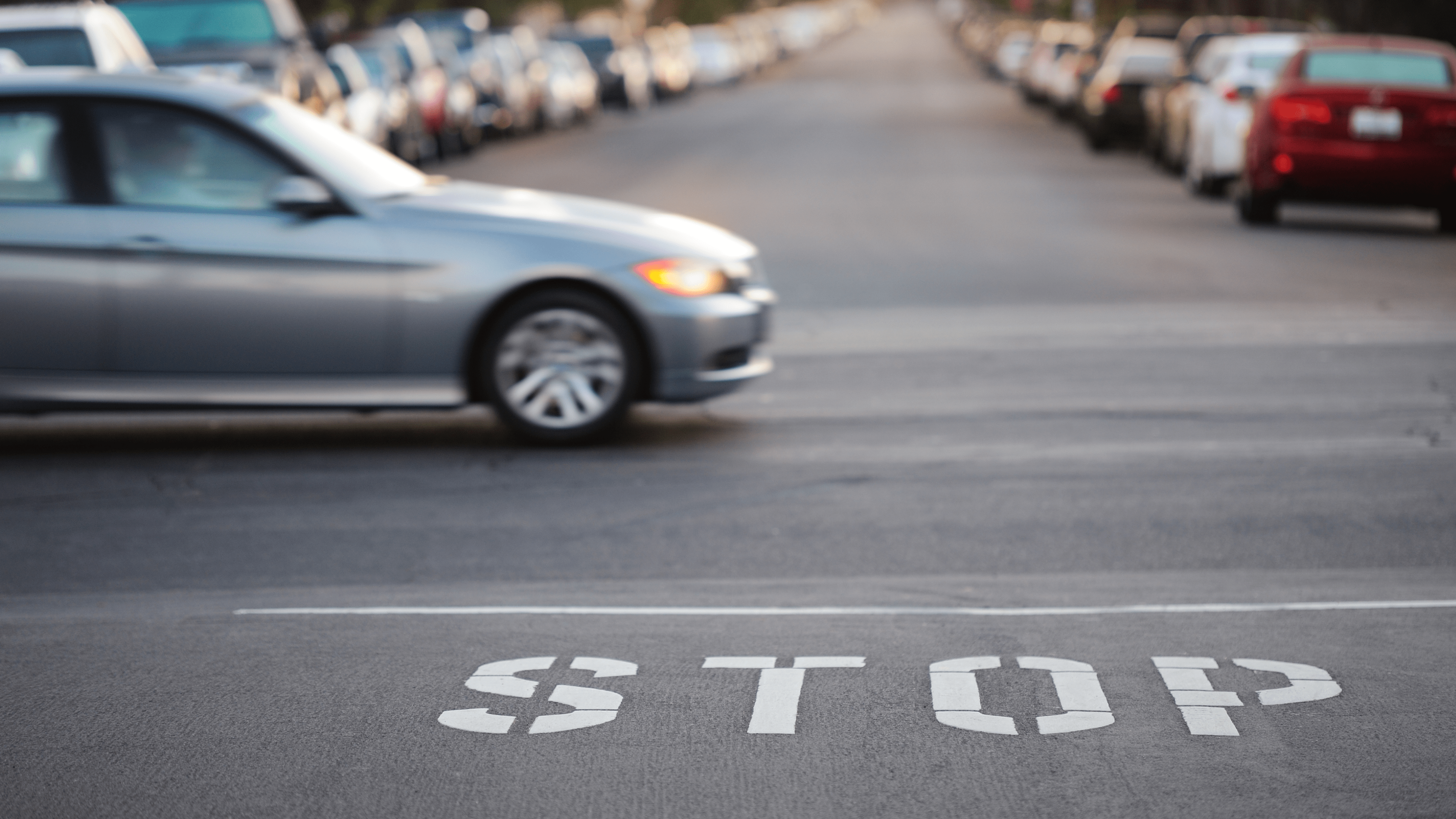 A road intersection with parked cars is seen in this file image.