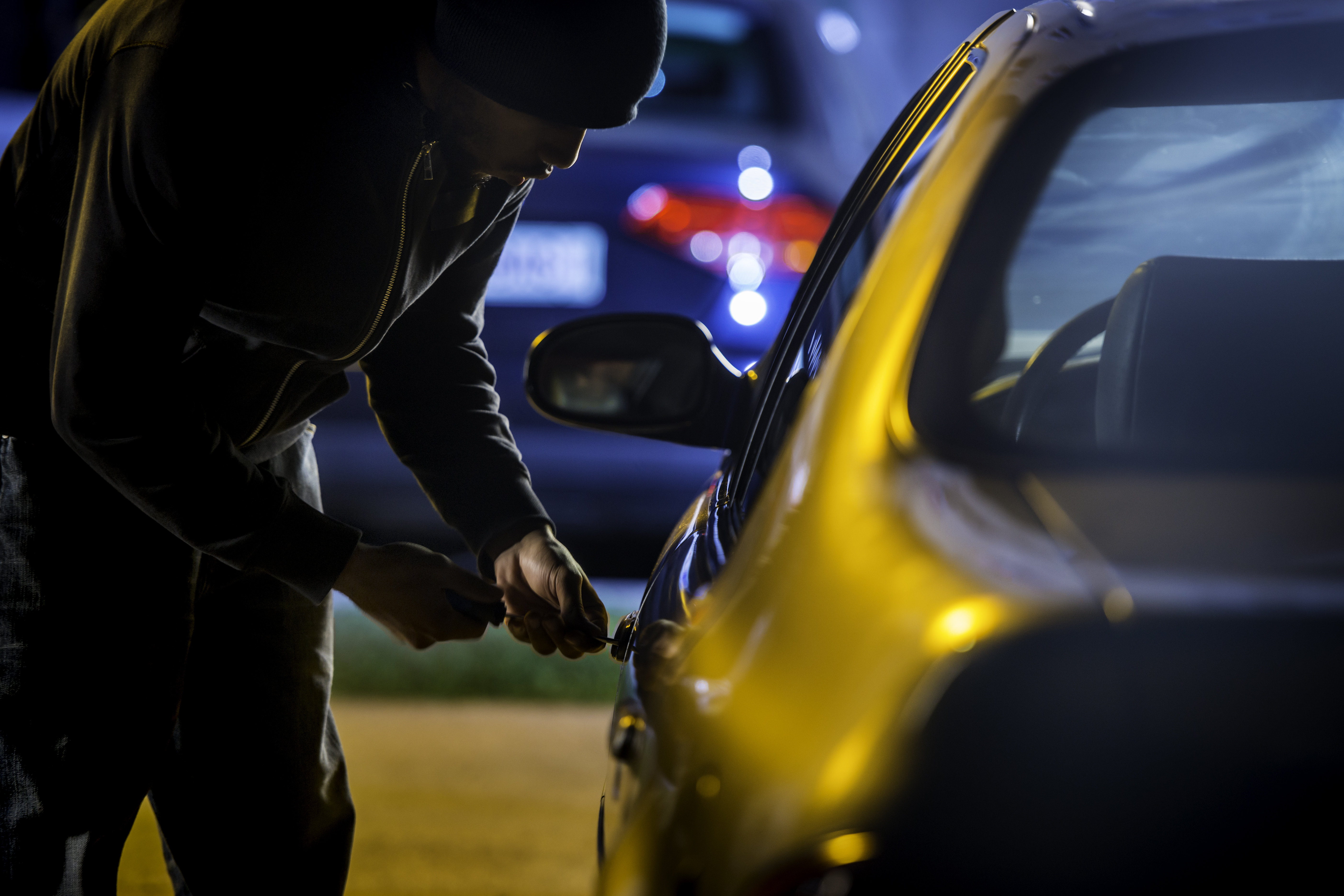 Car thief stealing a car. File stock image