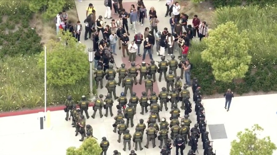 Law enforcement officers are seen approaching a protest encampment at UC Irvine on May 15, 2024. (KTLA)