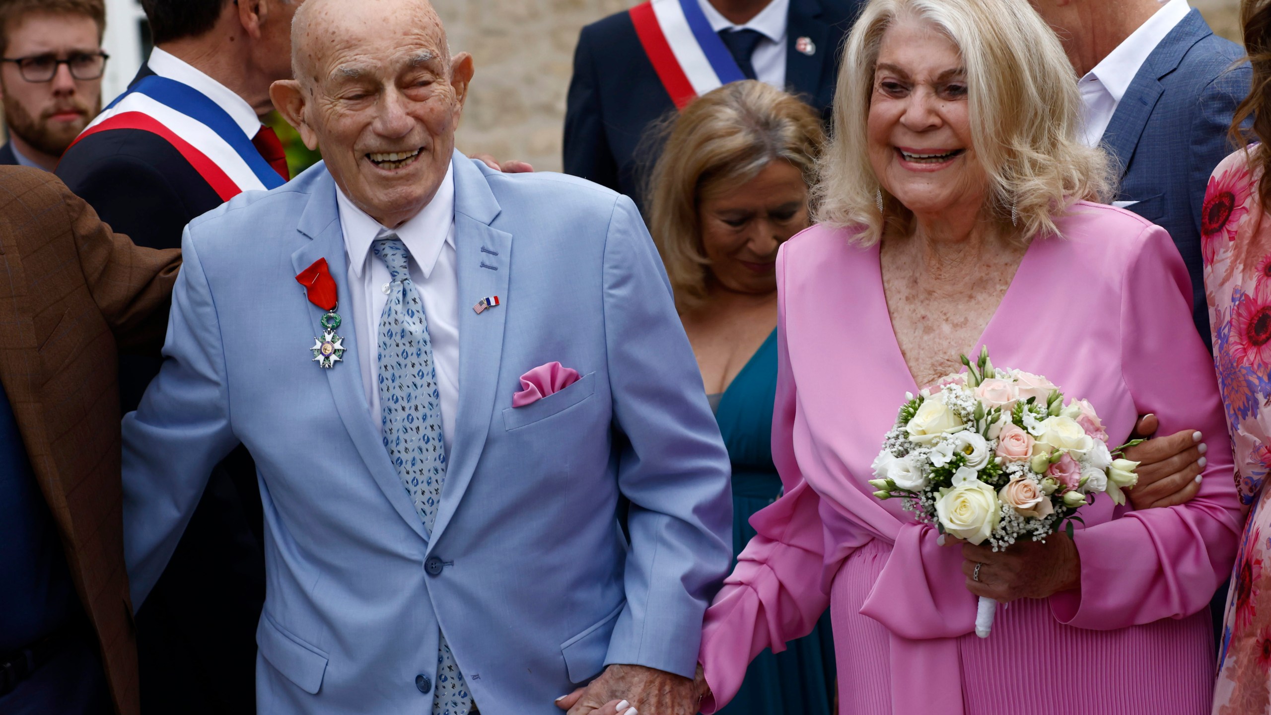 US WWII veteran Harold Terens, 100, left, and Jeanne Swerlin, 96, arrive to celebrate their wedding at the town hall of Carentan-les-Marais, in Normandy, northwestern France, on Saturday, June 8, 2024. Together, the collective age of the bride and groom was nearly 200. But Terens and his sweetheart Jeanne Swerlin proved that love is eternal as they tied the knot Saturday inland of the D-Day beaches in Normandy, France. (AP Photo/Jeremias Gonzalez)