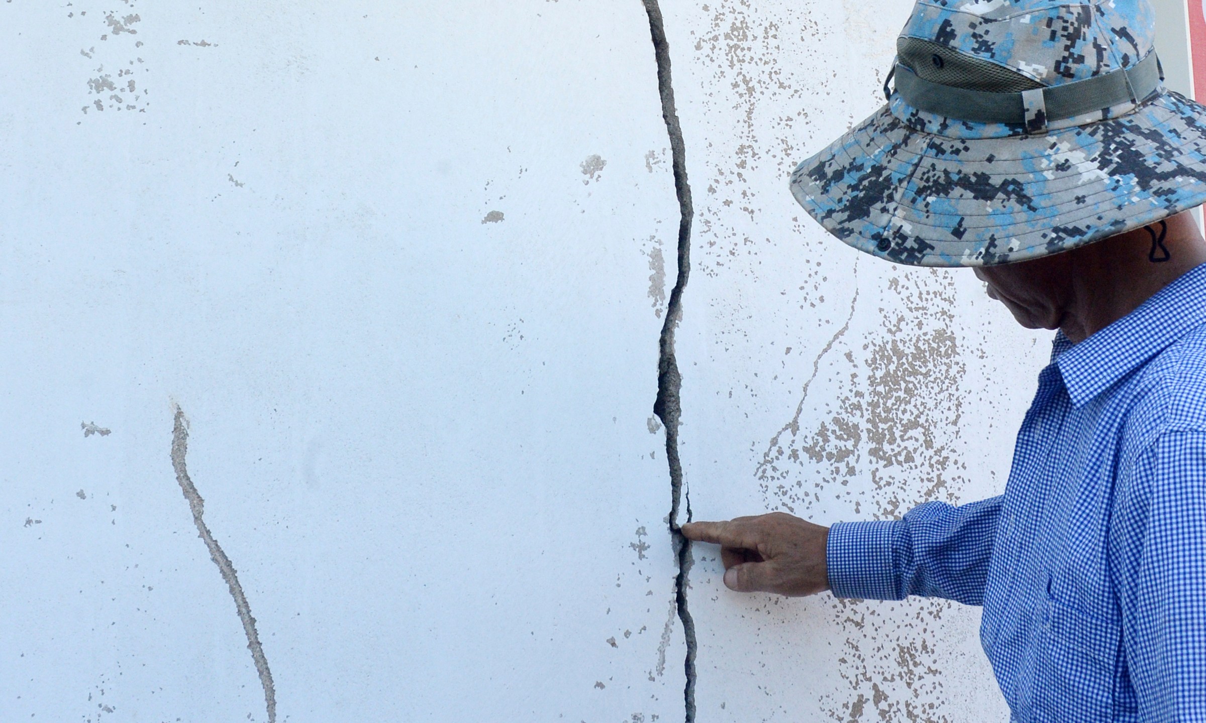 A resident points a cracked wall at a home damaged by an earthquake in Buan, South Korea, Wednesday, June 12, 2024. An earthquake broke windows and caused other minor damage in a fishing community in southwestern South Korea on Wednesday, but no injuries have been reported. (Kim Eul/Newsis via AP)