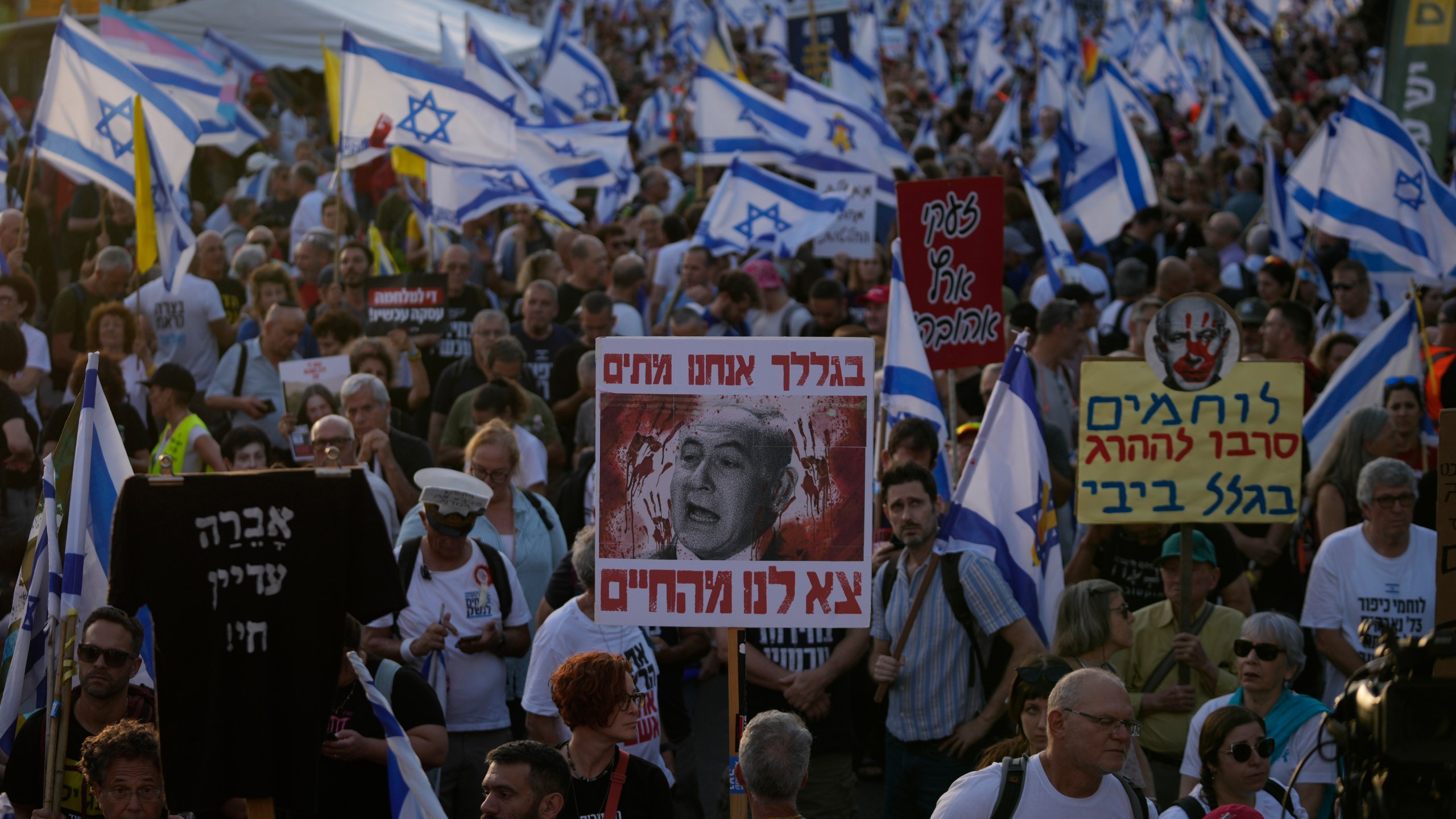 People take part in a protest against Israeli Prime Minister Benjamin Netanyahu's government, demanding new elections and the release of the hostages held in the Gaza Strip, outside of the Knesset, Israel's parliament, in Jerusalem, Monday, June 17, 2024. (AP Photo/Ohad Zwigenberg)