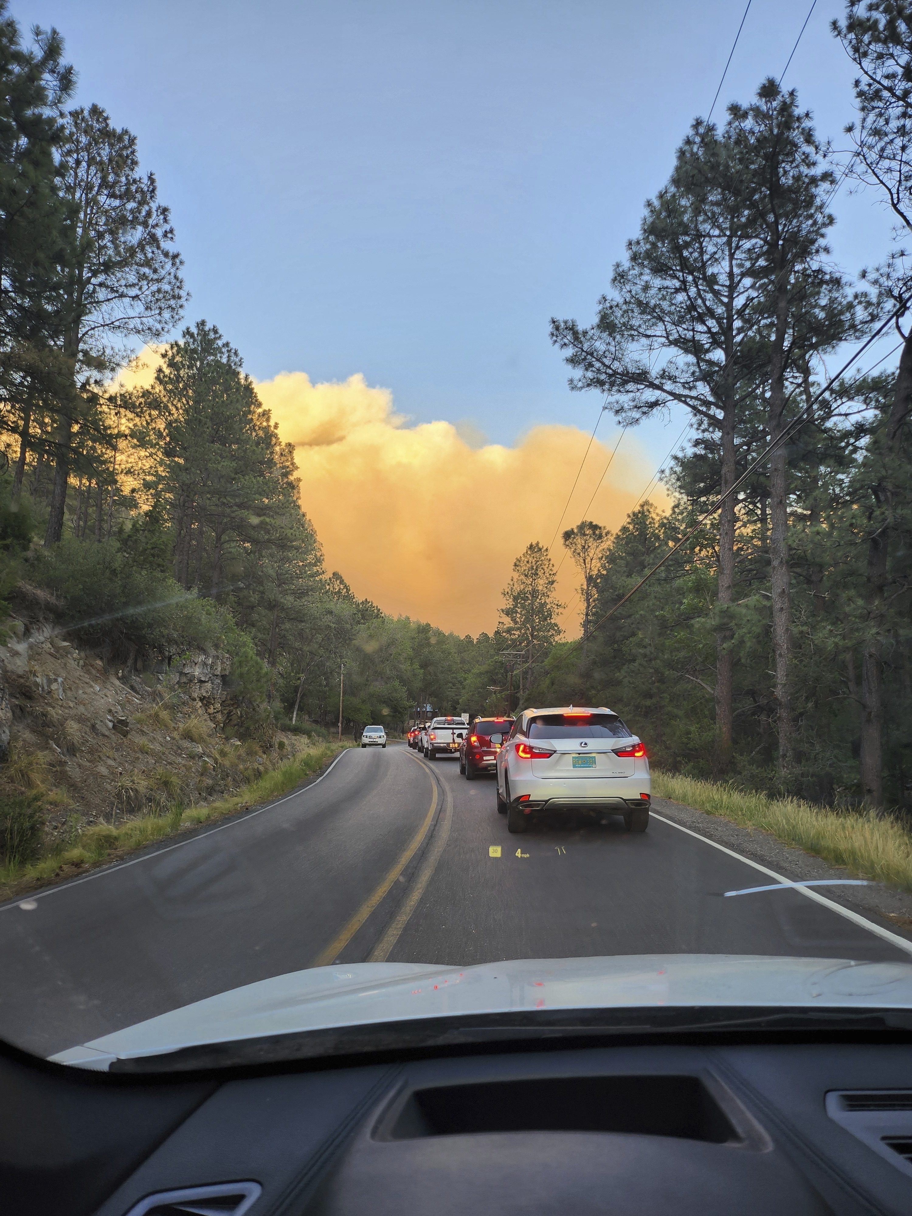 In this photo provided by Belinda Bukovitz, smoke rises from fires in Ruidoso, N.M., Monday, June 17, 2024. Thousands of southern New Mexico residents fled the mountainous village as a wind-whipped wildfire tore through homes and other buildings. (Belinda Bukovitz via AP)