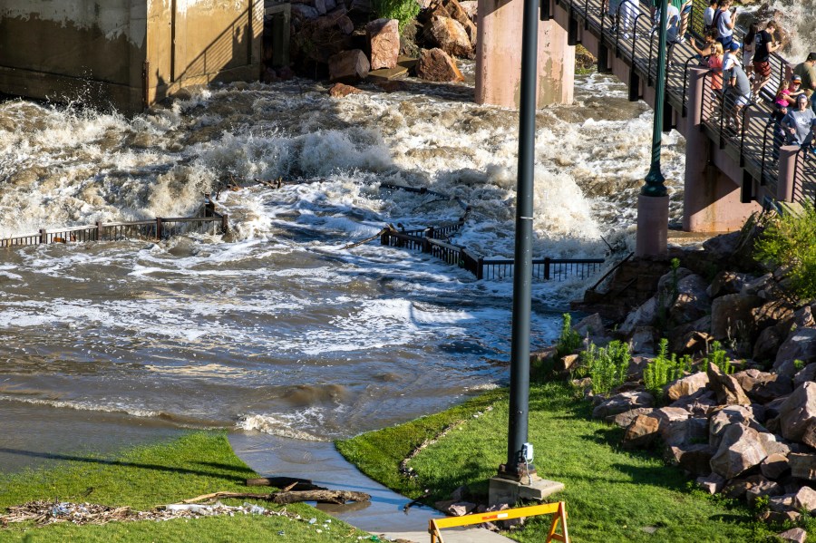 People on a viewing platform watch as Falls Park in Sioux Falls, S.D, was underwater on Saturday, June 22, 2024, after days of heavy rain led to flooding in the area. (AP Photo/Josh Jurgens)