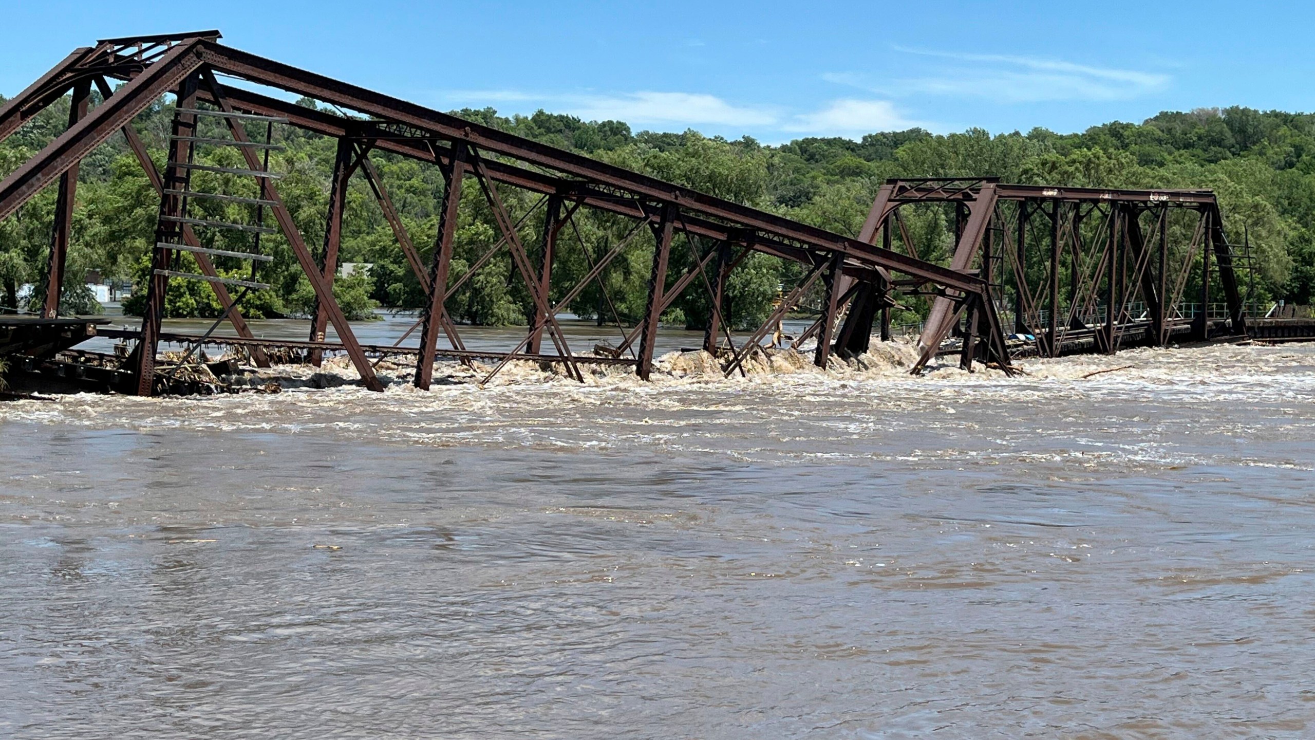 A railroad bridge connecting North Sioux City, S.D., with Sioux City, Iowa, is seen partially collapsed into the Big Sioux River due to flooding on Monday, June 24, 2024. (AP Photo/Margery A. Beck)