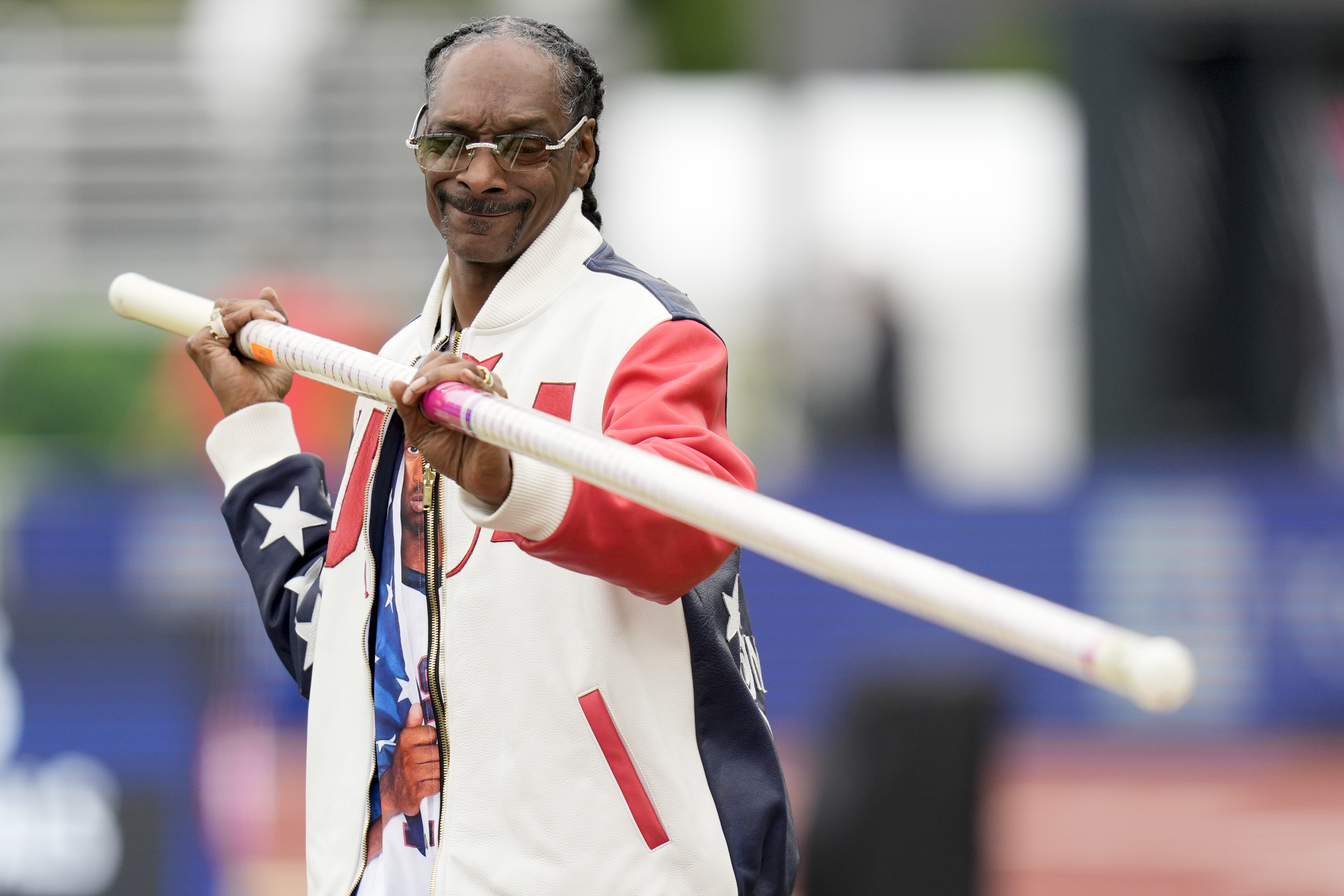 Play entertainer, Snoop Dogg gets a pole vault lesson during the U.S. Track and Field Olympic Team Trials Sunday, June 23, 2024, in Eugene, Ore. (AP Photo/Charlie Neibergall)