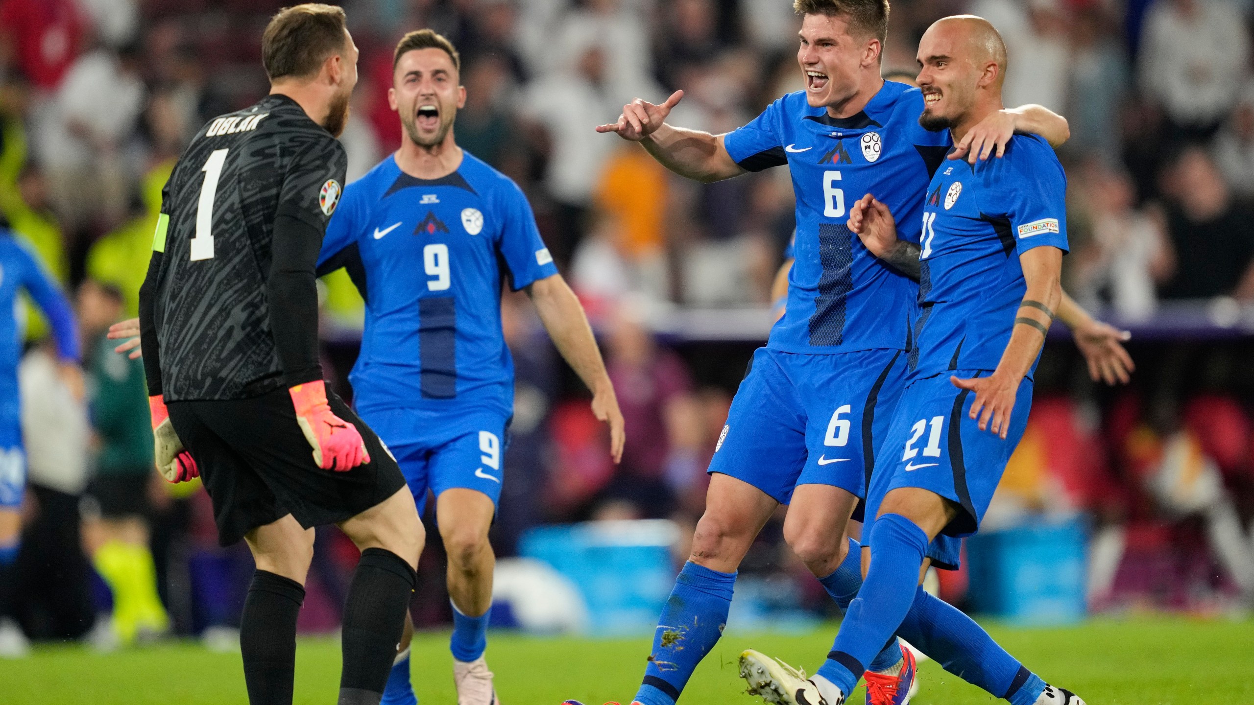 Slovenia's players celebrate at the end of a Group C match between the England and Slovenia at the Euro 2024 soccer tournament in Cologne, Germany, Tuesday, June 25, 2024. (AP Photo/Andreea Alexandru)