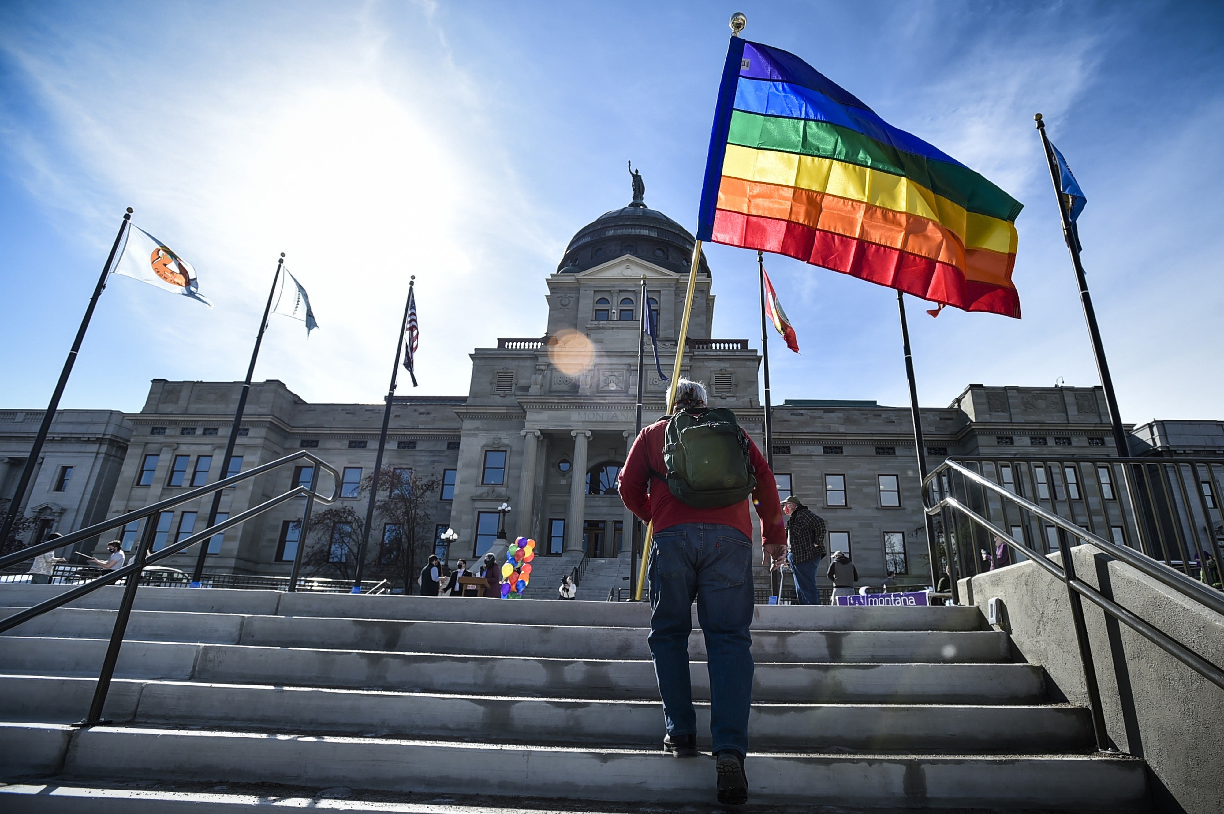 FILE - In this March 15, 2021, file photo Demonstrators gather on the steps of the Montana State Capitol protesting anti-LGBTQ+ legislation in Helena, Mont., March 15, 2021. A judge on Tuesday struck down a Montana law that defined “sex” in state law as only male or female, finding that it was unconstitutional. (Thom Bridge/Independent Record via AP, File)