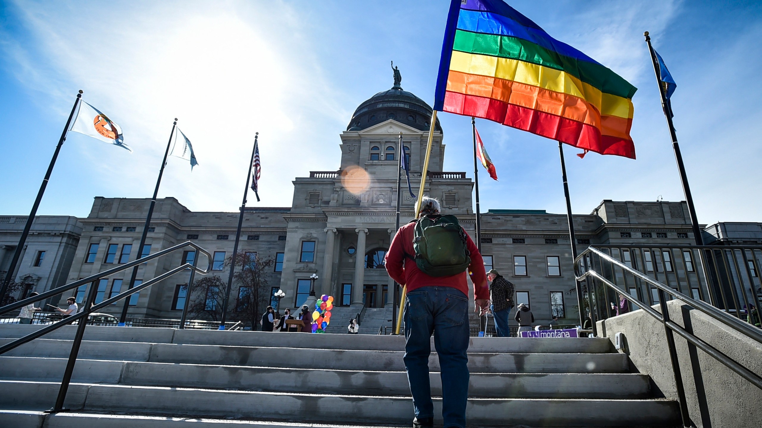 FILE - In this March 15, 2021, file photo Demonstrators gather on the steps of the Montana State Capitol protesting anti-LGBTQ+ legislation in Helena, Mont., March 15, 2021. A judge on Tuesday struck down a Montana law that defined “sex” in state law as only male or female, finding that it was unconstitutional. (Thom Bridge/Independent Record via AP, File)