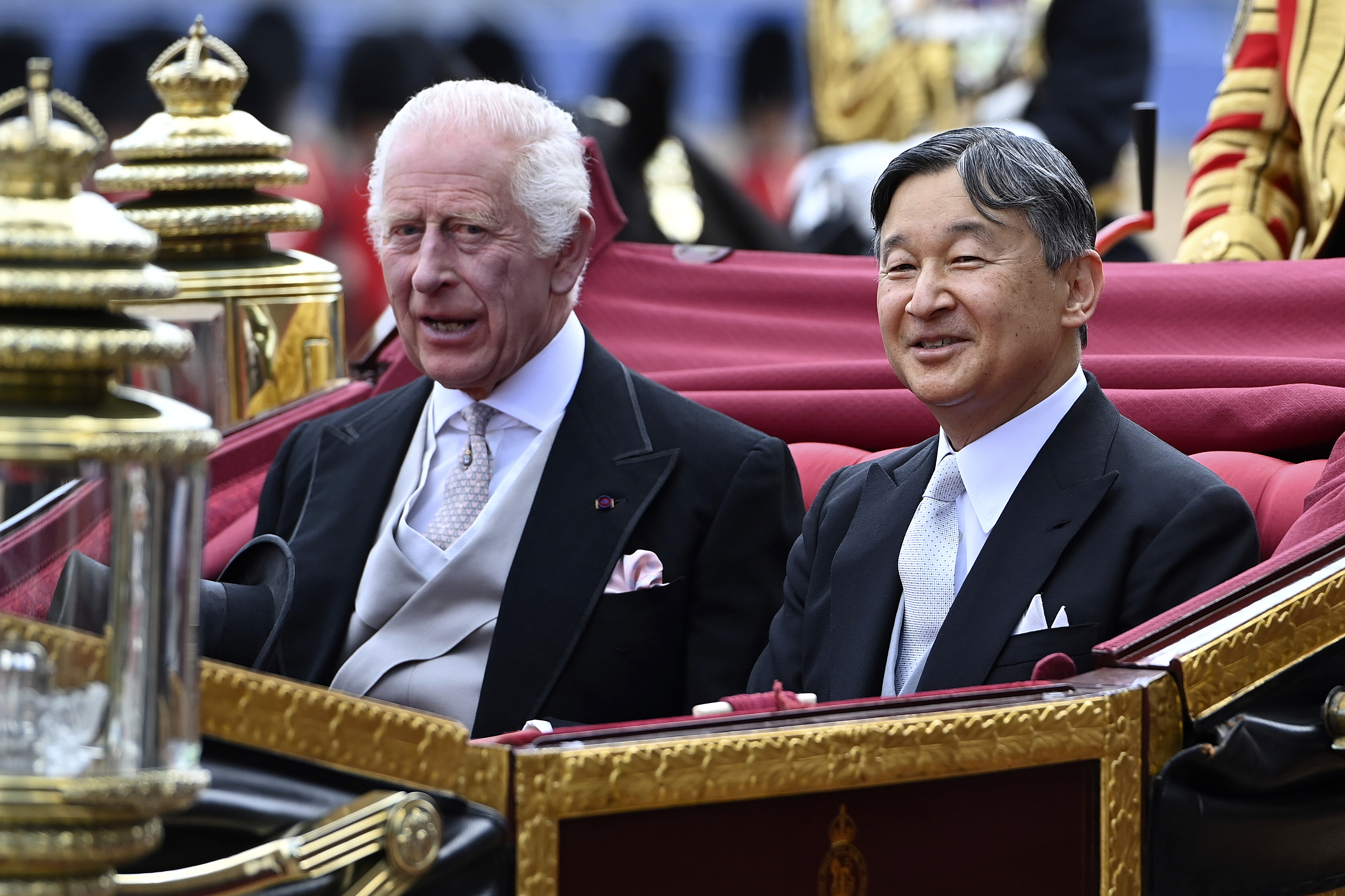 Britain's King Charles III and Japan's Emperor Naruhito ride a carriage during a welcome ceremony for Naruhito's state visit to Britain, at Horse Guards Parade, London, Tuesday, June 25, 2024. (Eddie Mulholland/Pool Photo via AP)