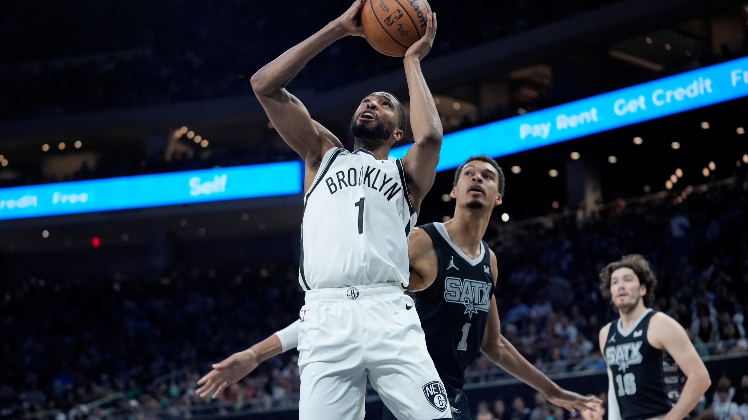 FILE - Brooklyn Nets forward Mikal Bridges, left, scores past San Antonio Spurs center Victor Wembanyama, center, during the first half of an NBA basketball game in Austin, Texas, March 17, 2024. Bridges is being traded from the Nets to the New York Knicks, where he will join Jalen Brunson and other former Villanova teammates, a person with knowledge of the details said Tuesday, June 25. (AP Photo/Eric Gay, File)