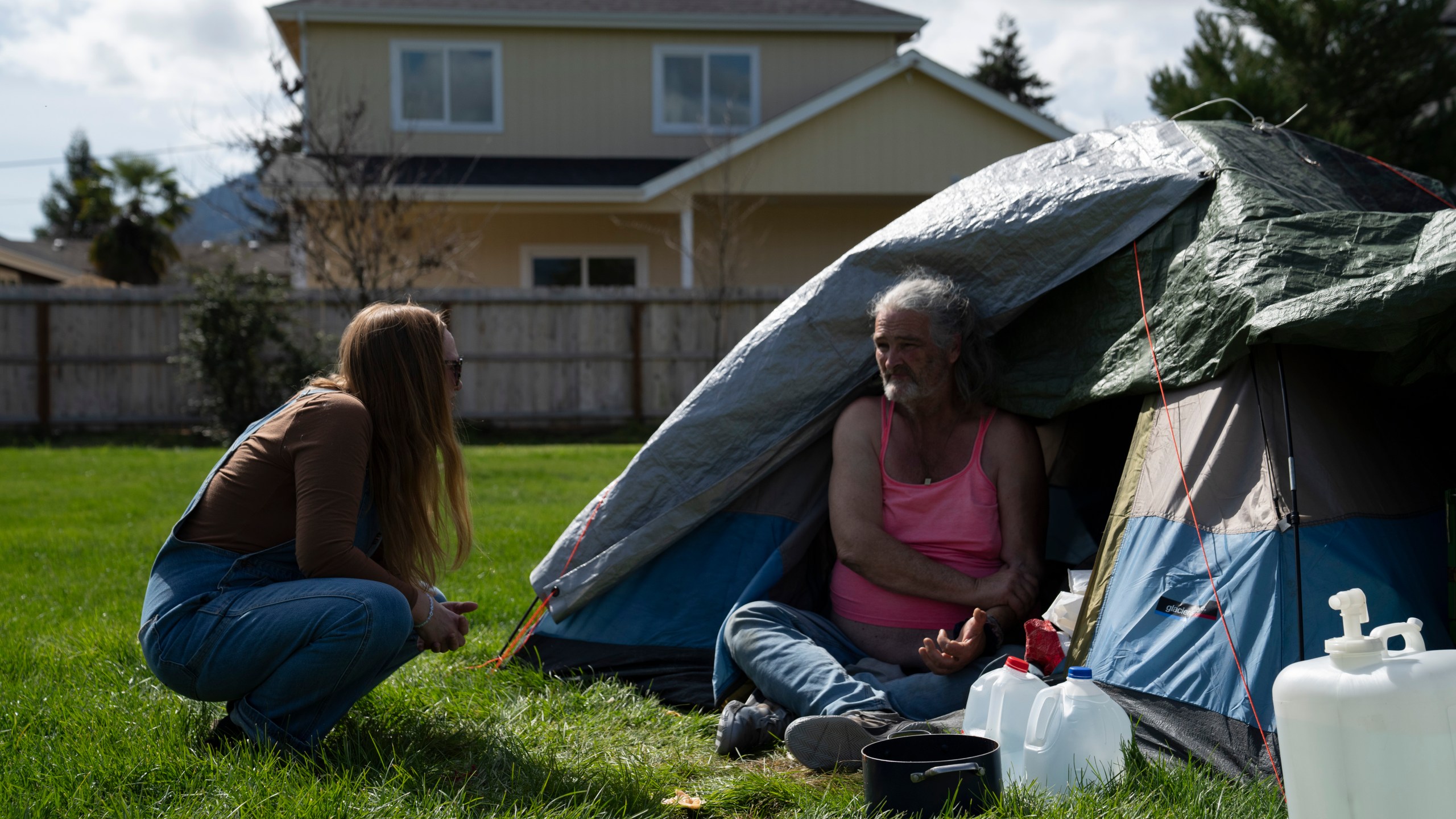 FILE - Cassy Leach, a nurse who leads a group of volunteers who provide food, medical care and other basic goods to the hundreds of homeless people living in the parks, talks to Kimberly Marie, who is homeless and camping in Fruitdale Park on March 21, 2024, in Grants Pass, Ore. On Friday, June 28, the Supreme Court ruled that cities can enforce bans on homeless people sleeping outdoors in West Coast areas where shelter space is lacking. (AP Photo/Jenny Kane, File)