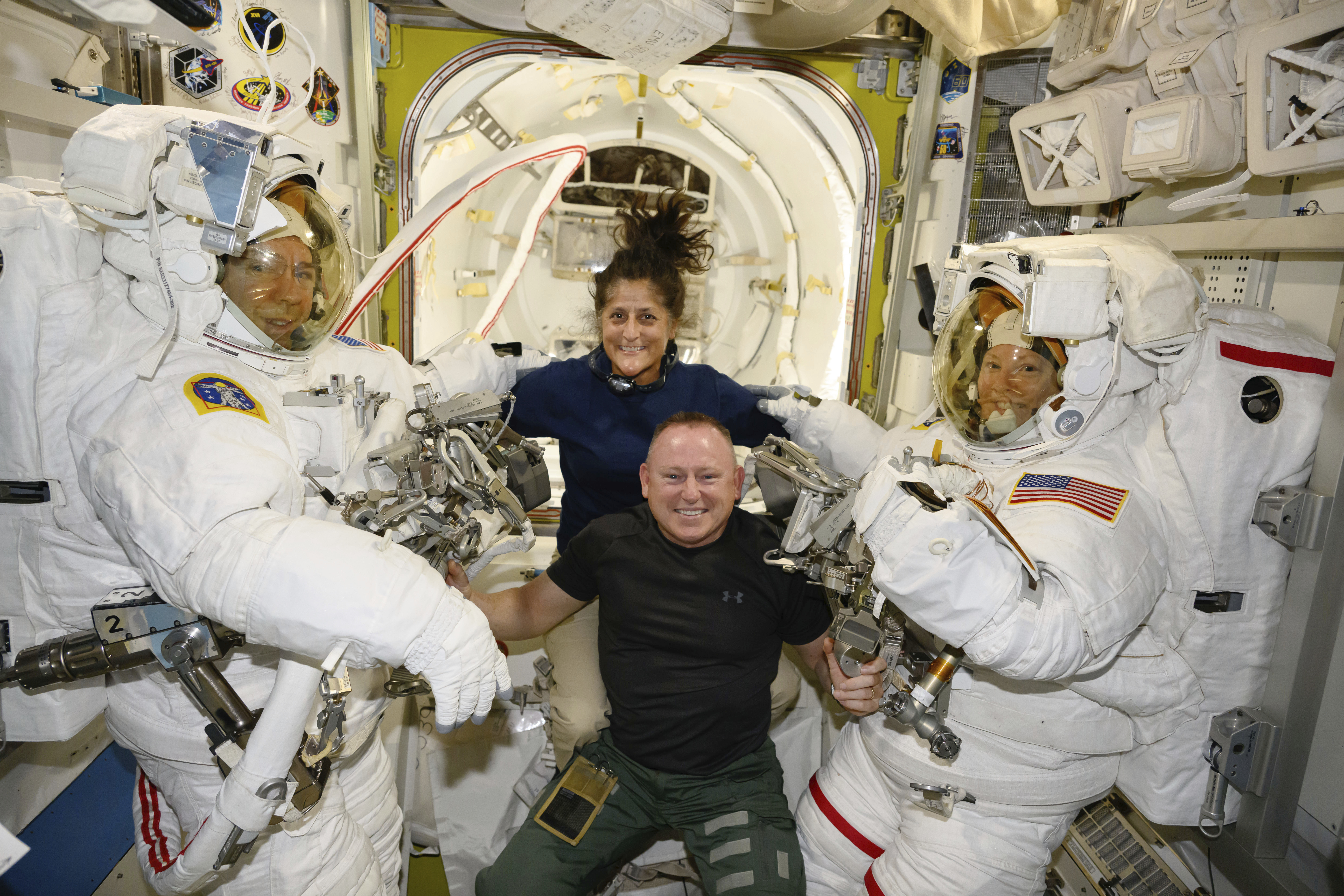 In this photo provided by NASA, Boeing Crew Flight Test astronauts Suni Williams and Butch Wilmore, center, pose with Expedition 71 Flight Engineers Mike Barratt, left, and Tracy Dyson, both NASA astronauts, in their spacesuits aboard the International Space Station's Quest airlock on June 24, 2024. (NASA via AP)